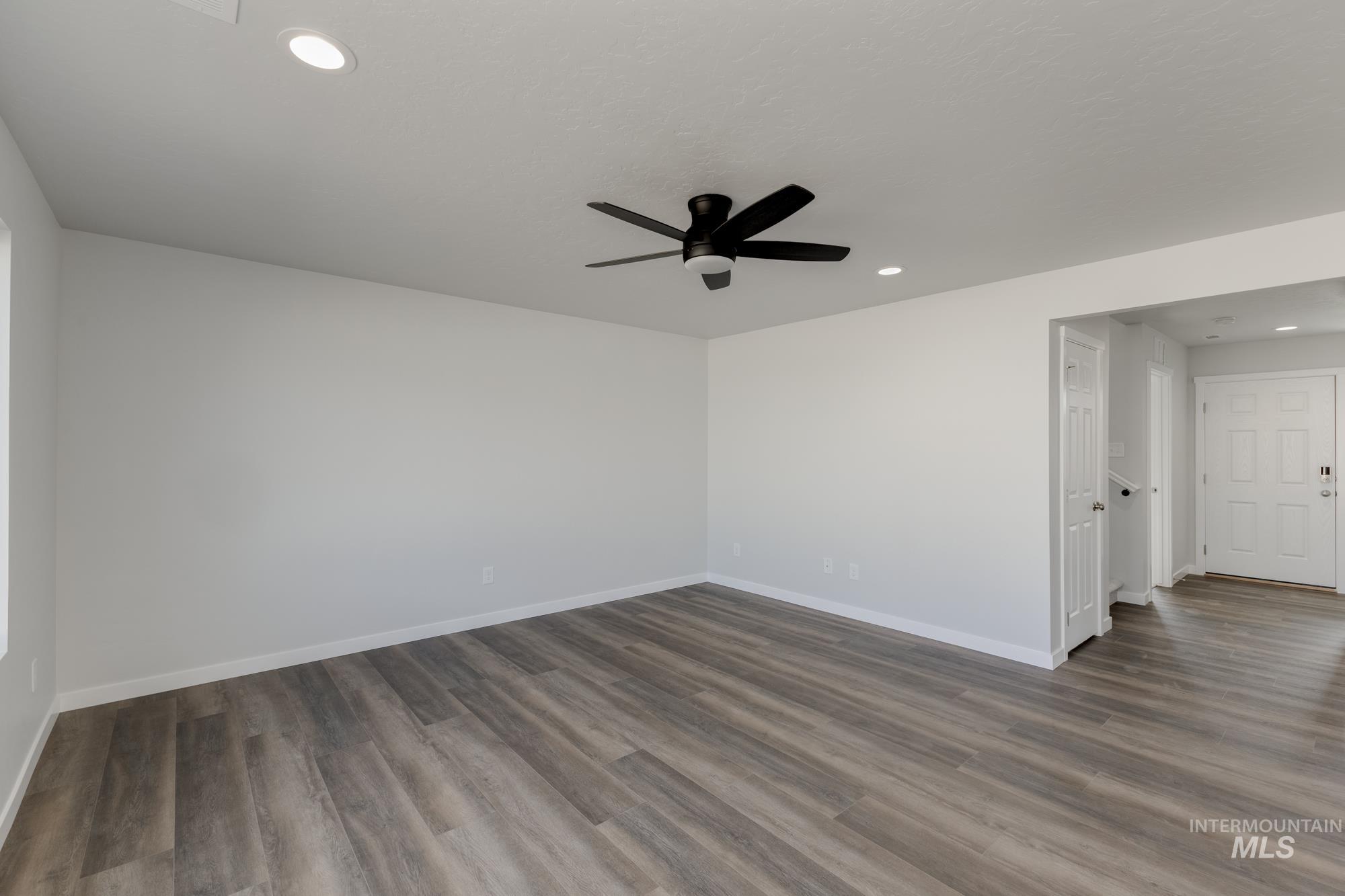 Spare room with recessed lighting, dark wood-type flooring, and a ceiling fan