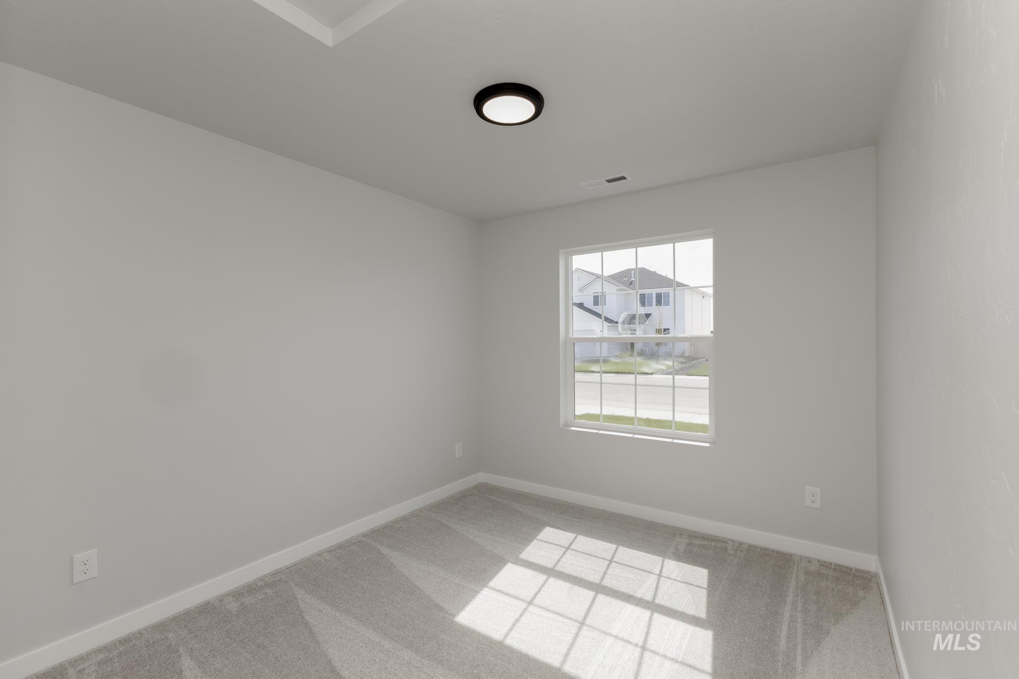 Empty room with light colored carpet