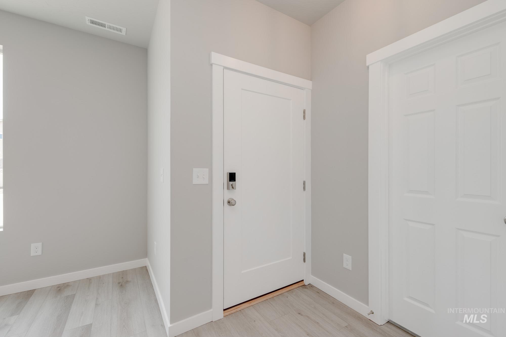 Entryway with baseboards and light wood finished floors