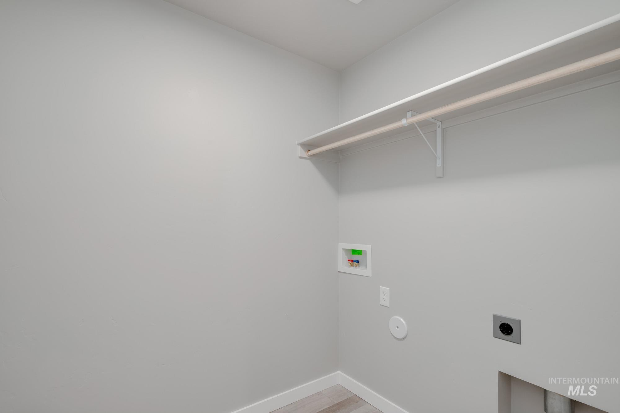 Washroom featuring electric dryer hookup, hookup for a washing machine, and light wood-style floors