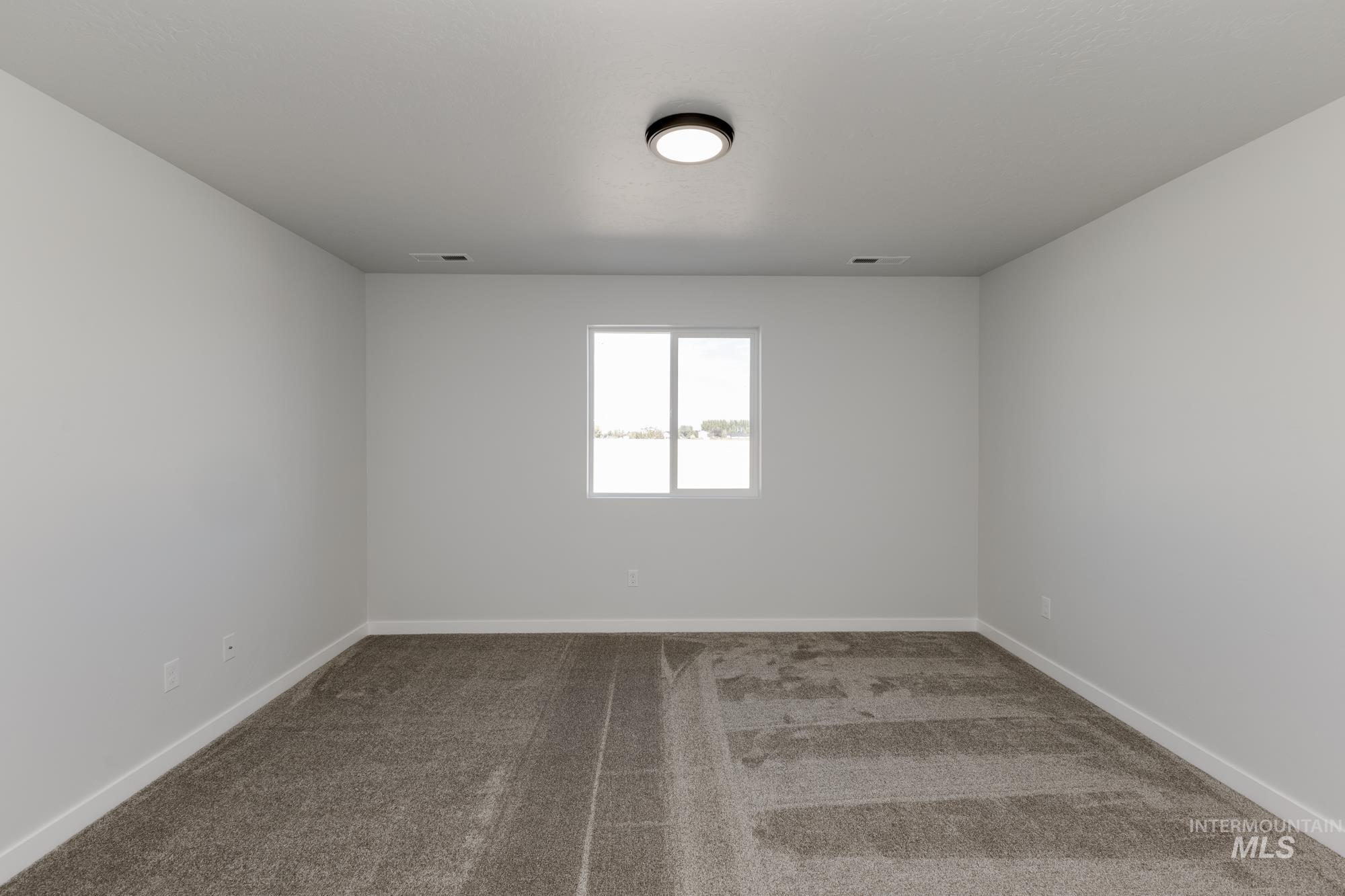 Spare room with light carpet and baseboards
