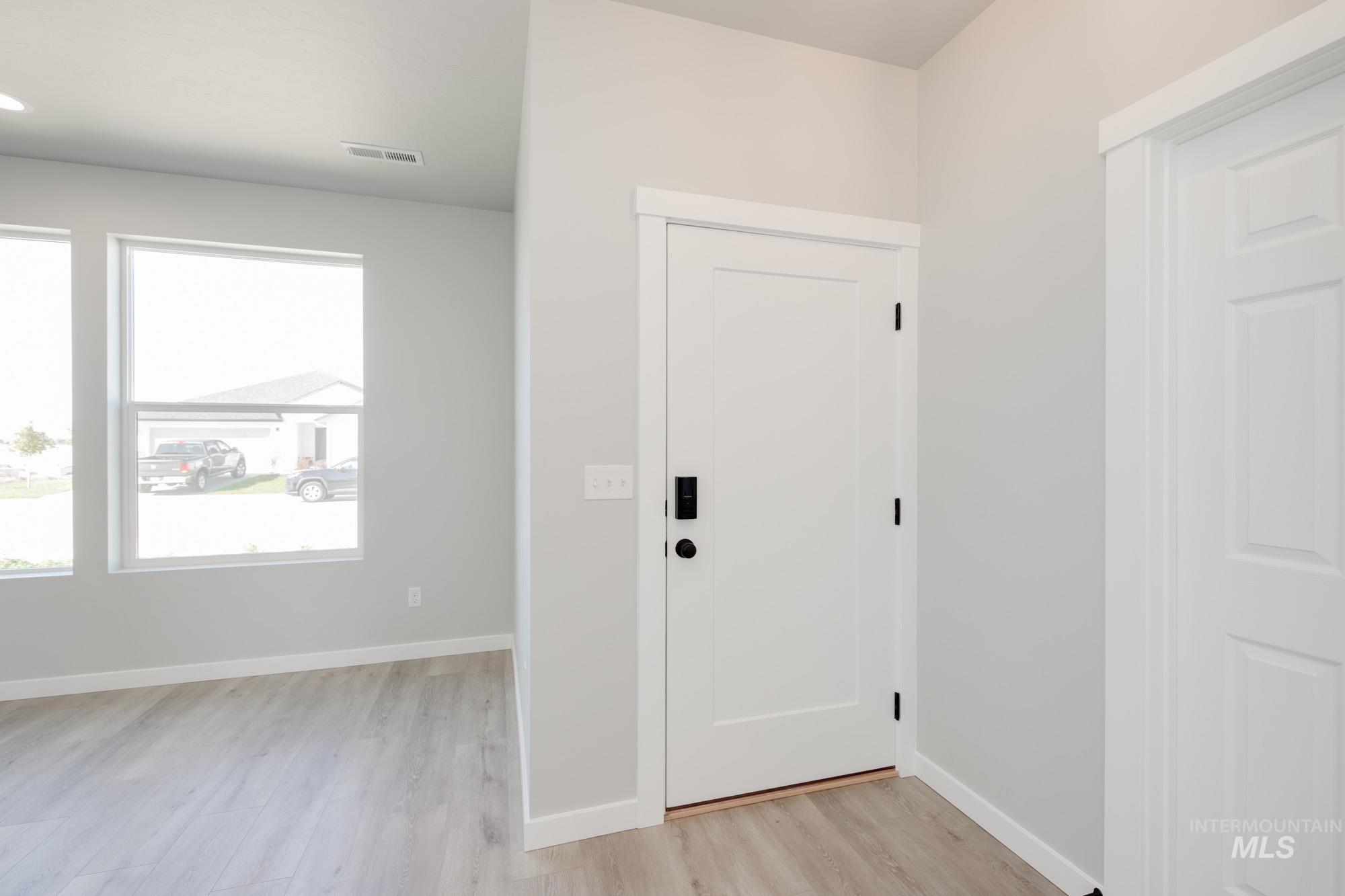 Foyer entrance with baseboards and light wood-style flooring