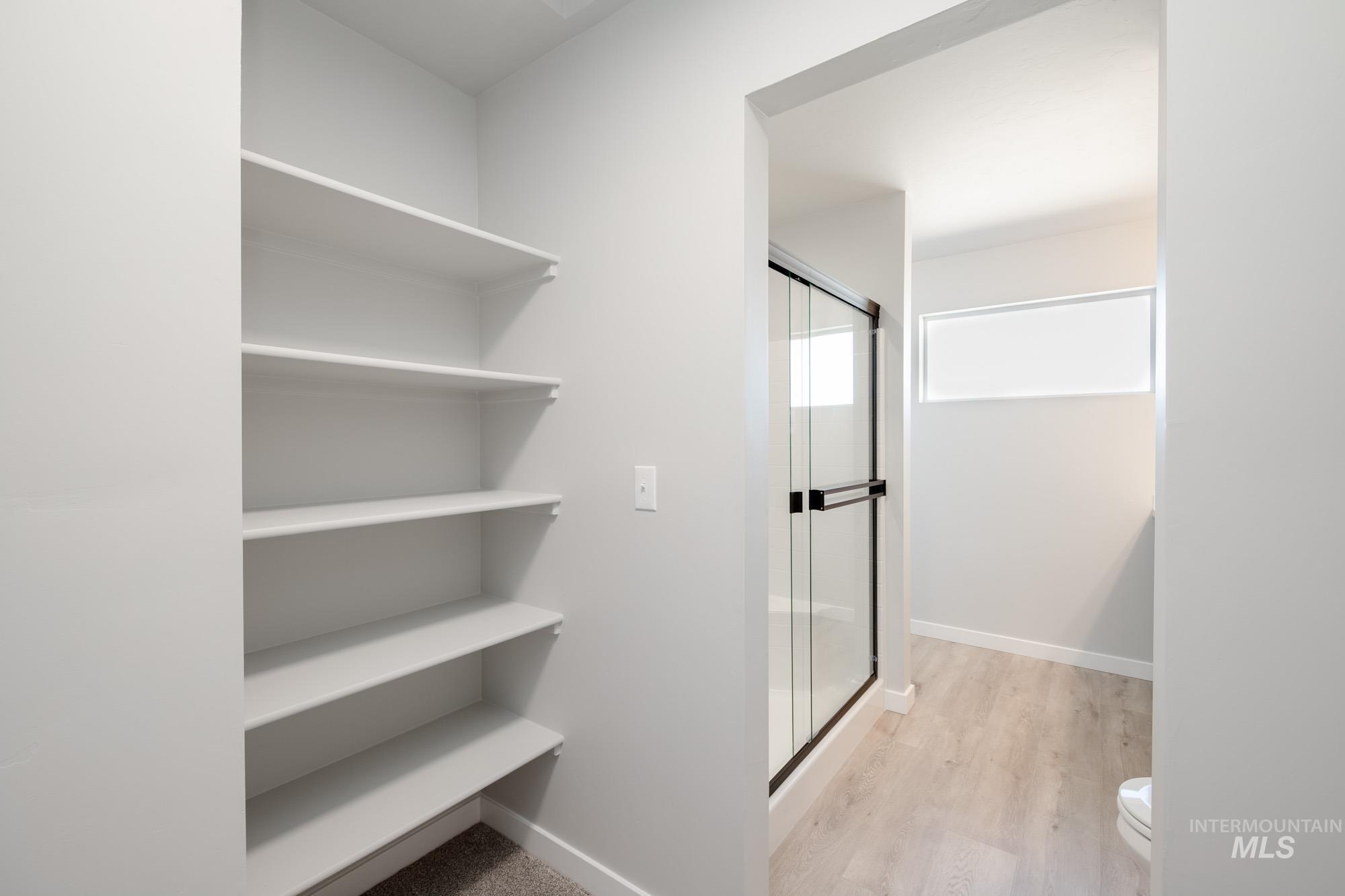 Bathroom with a shower stall and light wood-type flooring