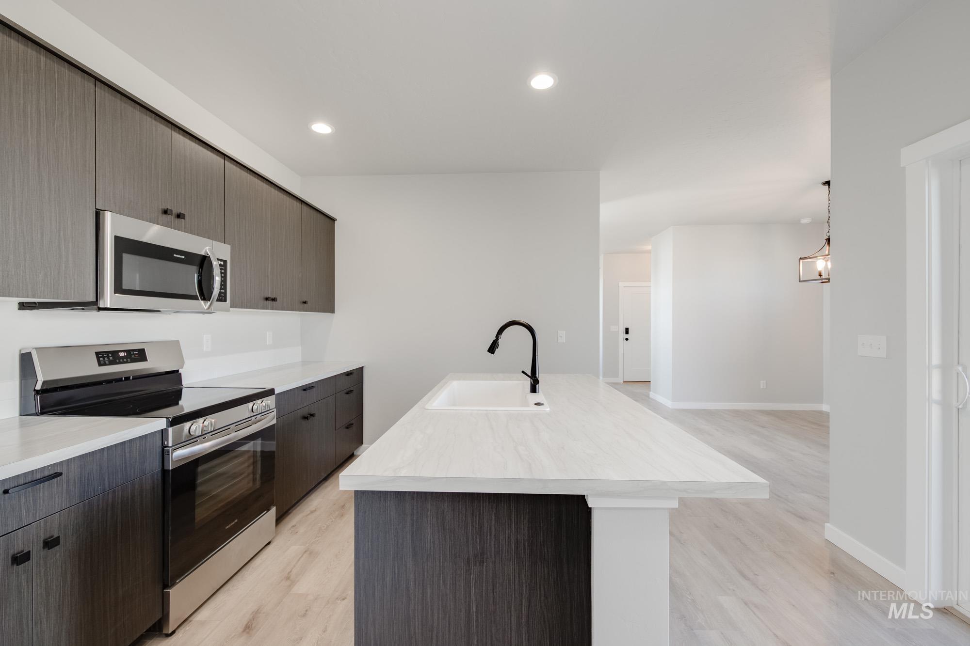 Kitchen featuring stainless steel appliances, an island with sink, light wood-style flooring, modern cabinets, and recessed lighting