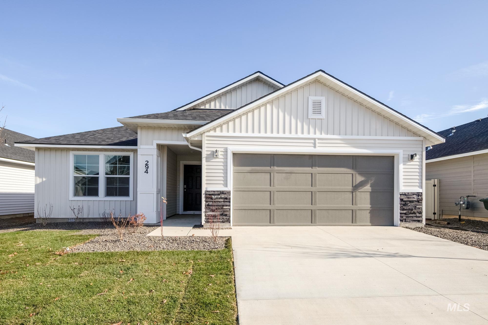 View of front of house with board and batten siding, a shingled roof, an attached garage, concrete driveway, and a front lawn