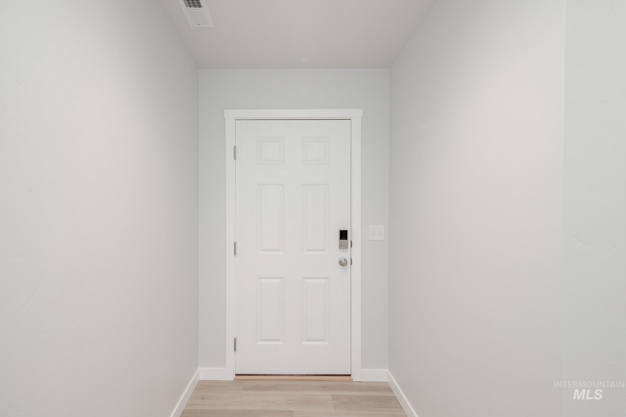 Doorway to outside with wood finished floors and baseboards