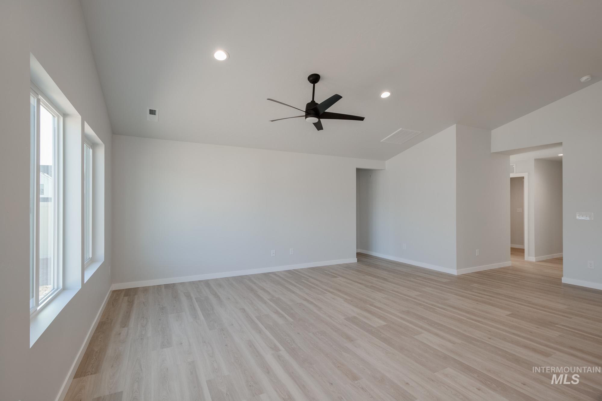 Spare room featuring lofted ceiling, light wood finished floors, recessed lighting, and a ceiling fan