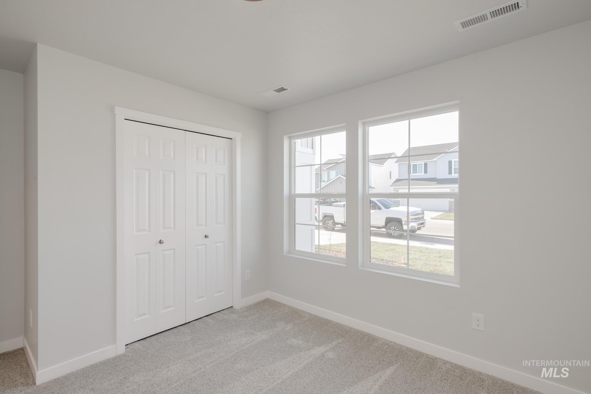 Unfurnished bedroom featuring light colored carpet and a closet