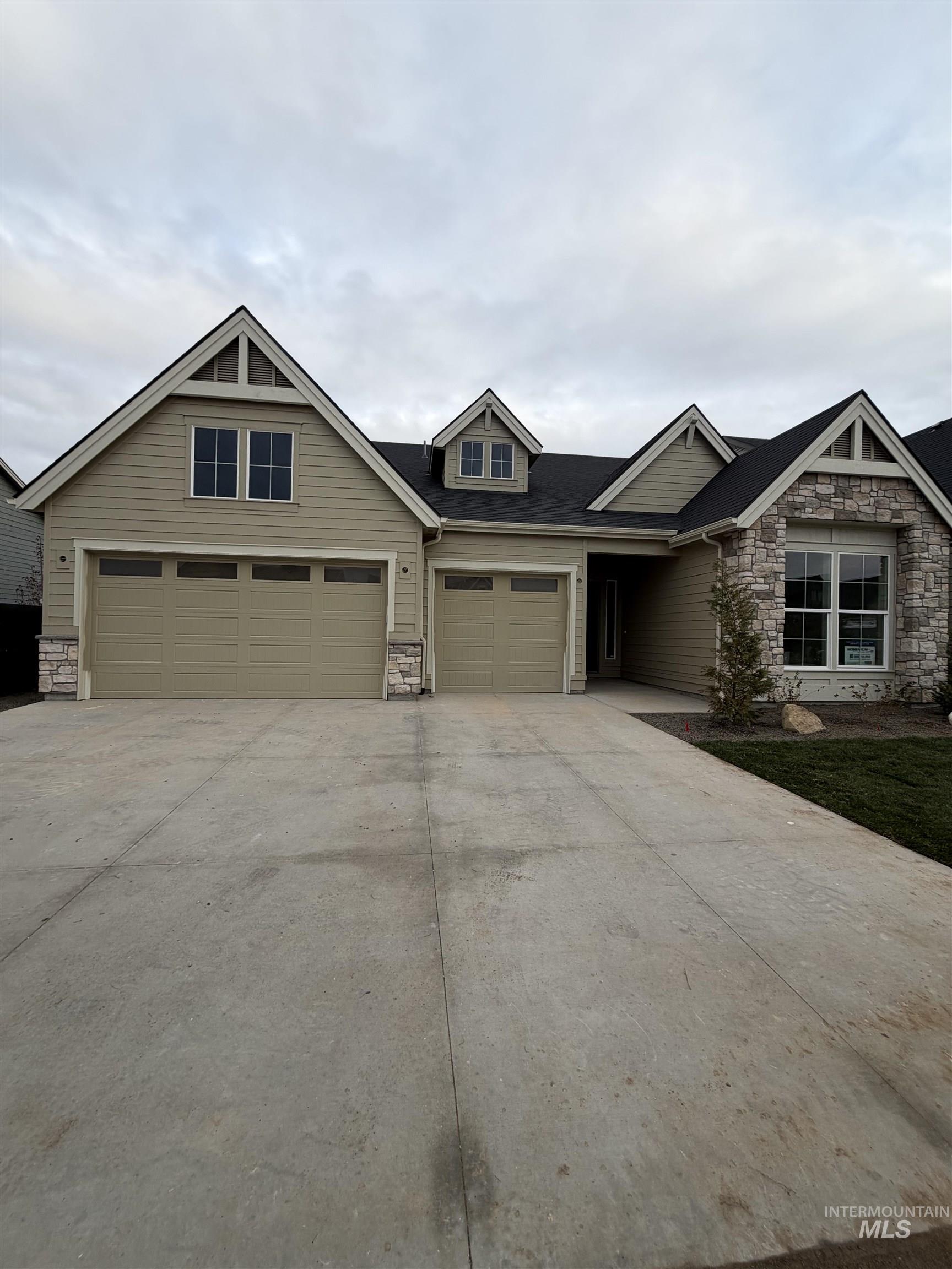 Craftsman house featuring stone siding and driveway