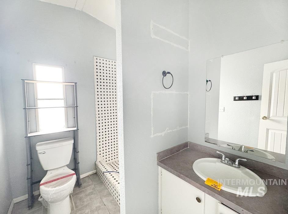 Bathroom with vanity, a shower stall, and light tile patterned flooring