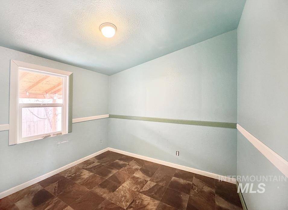 Unfurnished room with stone finish floors and a textured ceiling