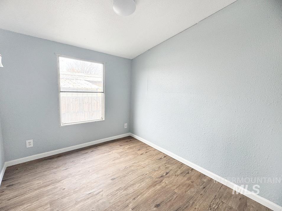 Unfurnished room featuring wood finished floors and a textured ceiling