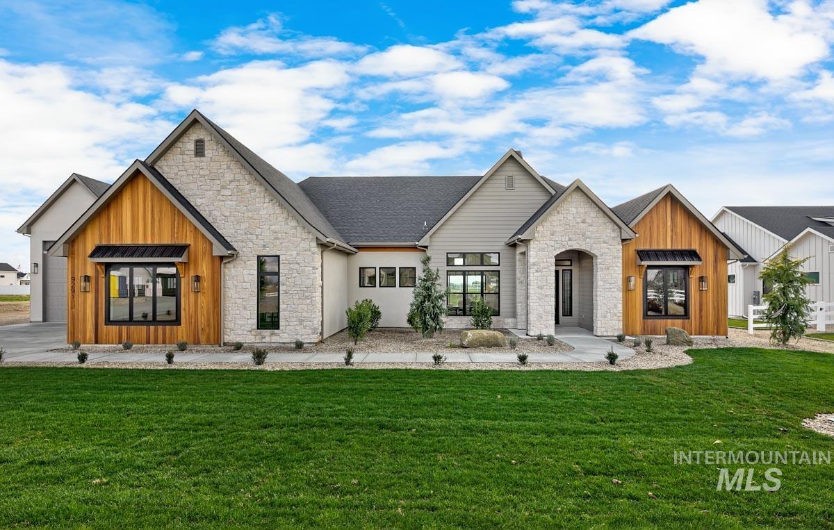 View of front of home with stone siding, board and batten siding, and a front lawn