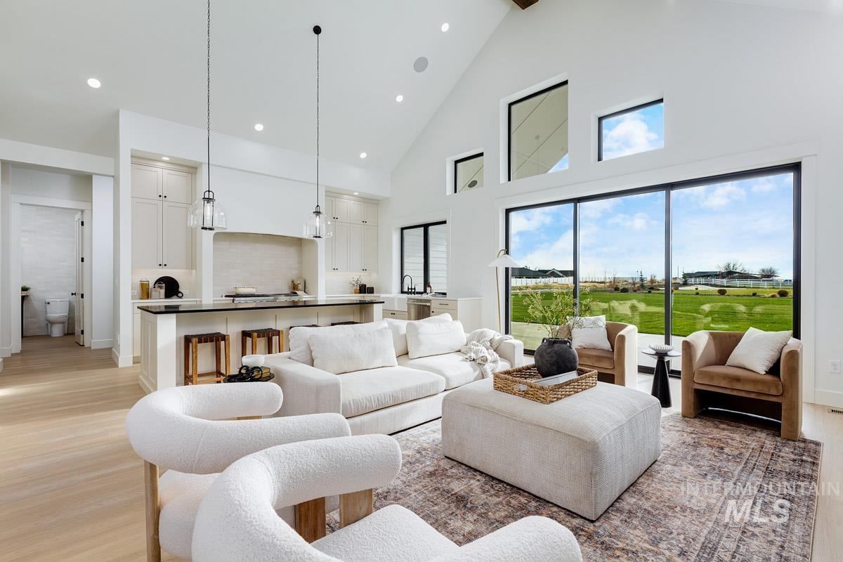 Living area with high vaulted ceiling and light wood-style flooring