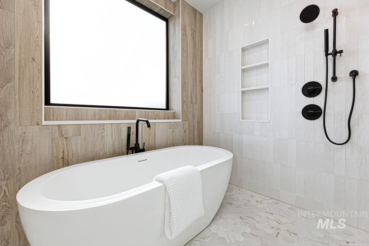Full bath with a freestanding bath and tile walls