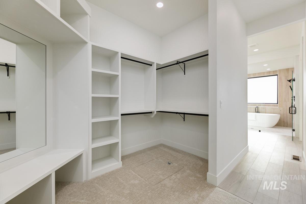 Spacious closet featuring light colored carpet
