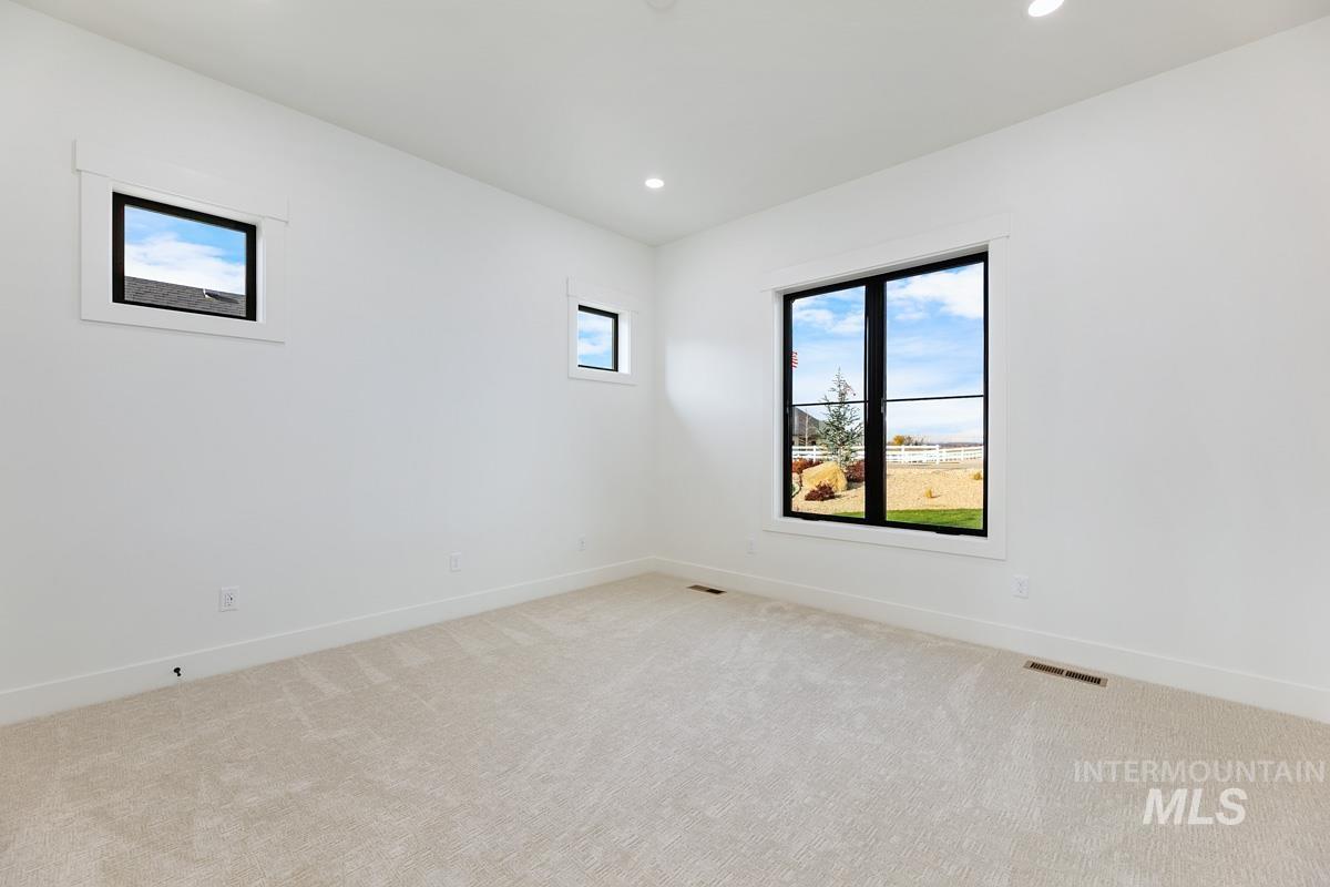 Unfurnished room with plenty of natural light, light colored carpet, and recessed lighting