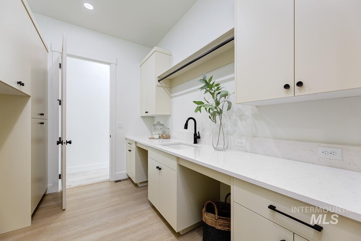 Laundry room with light wood-style floors and recessed lighting
