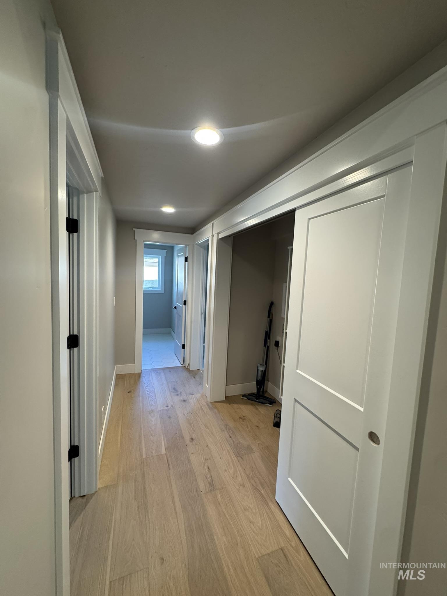 Hall featuring light wood-type flooring and baseboards