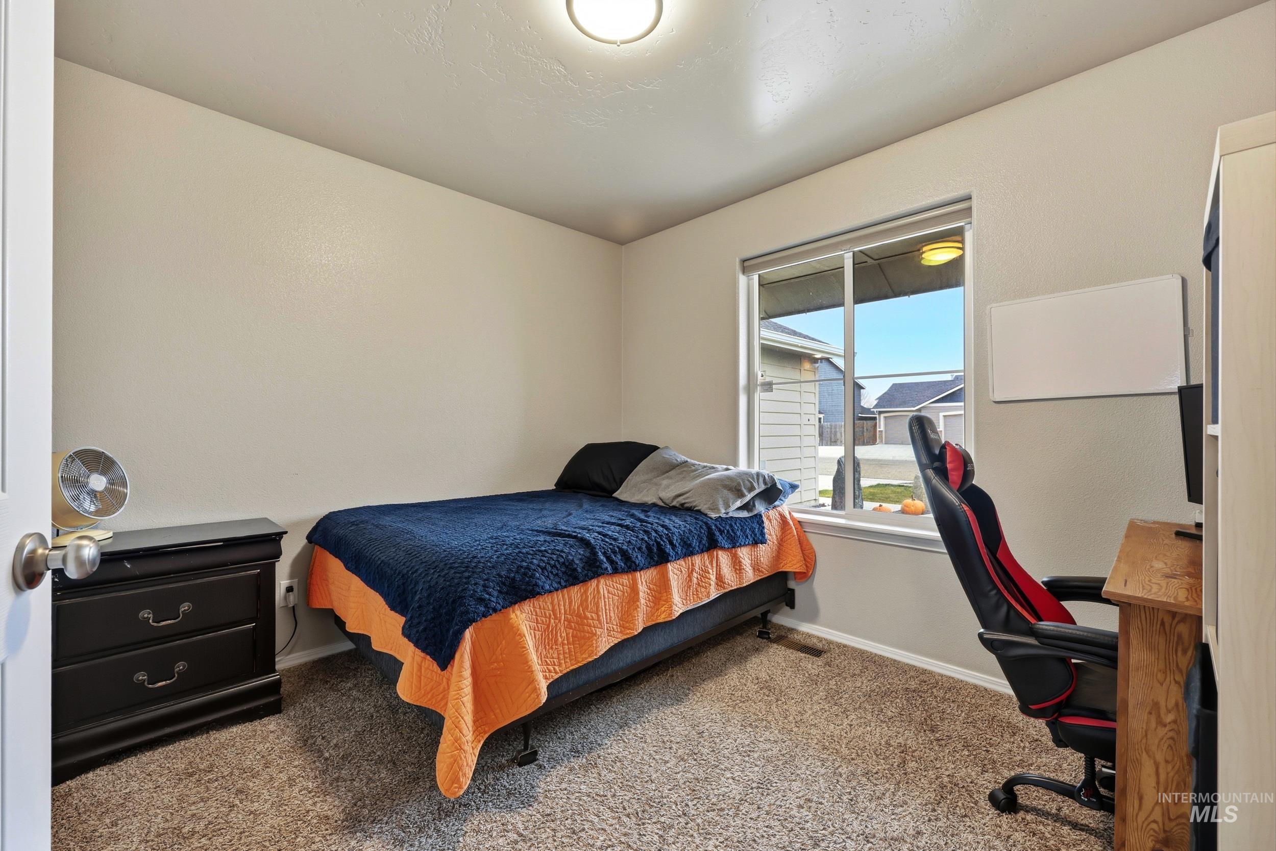 Bedroom with carpet flooring and an office area