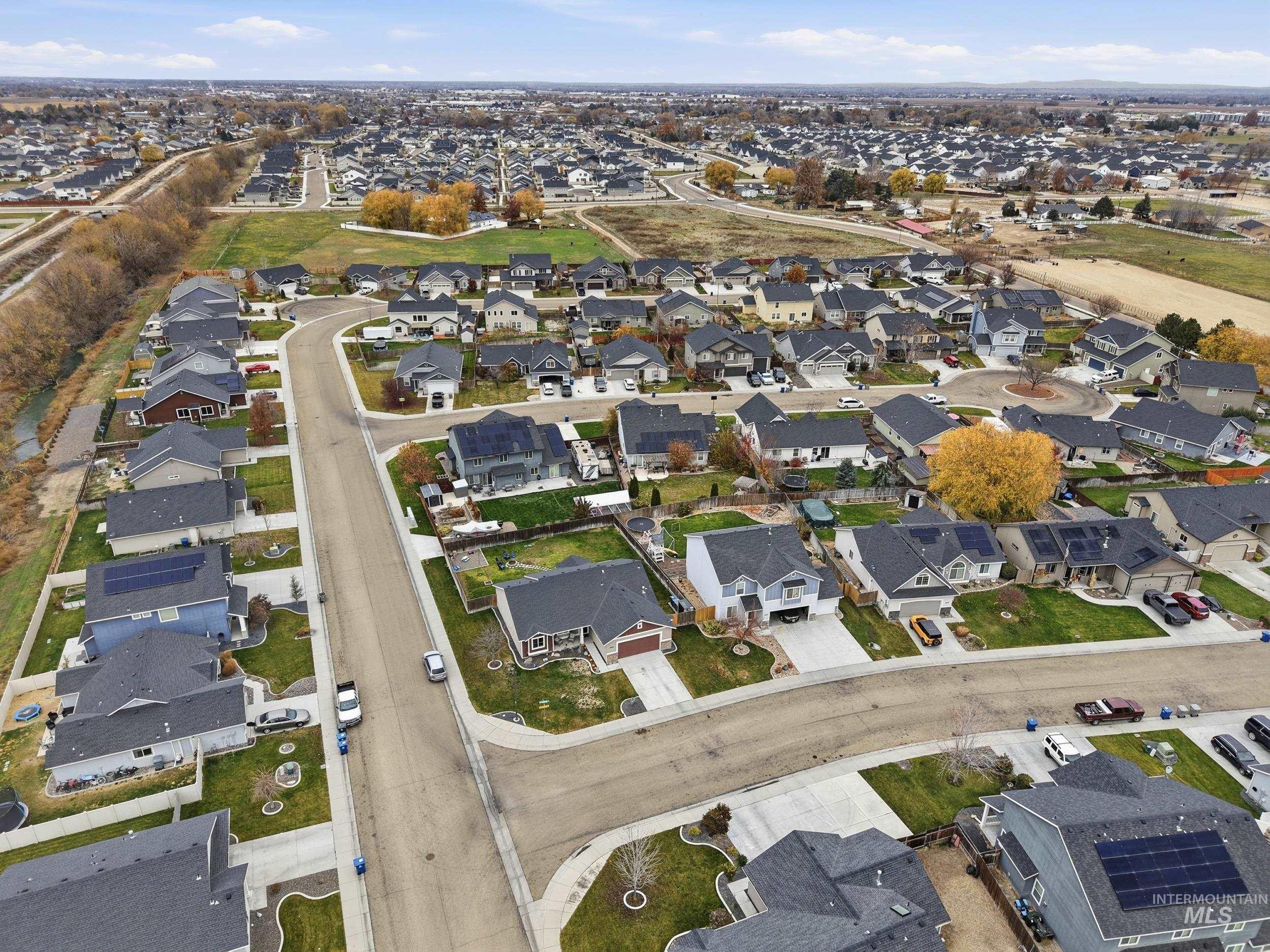 Aerial view of property and surrounding area featuring nearby suburban area