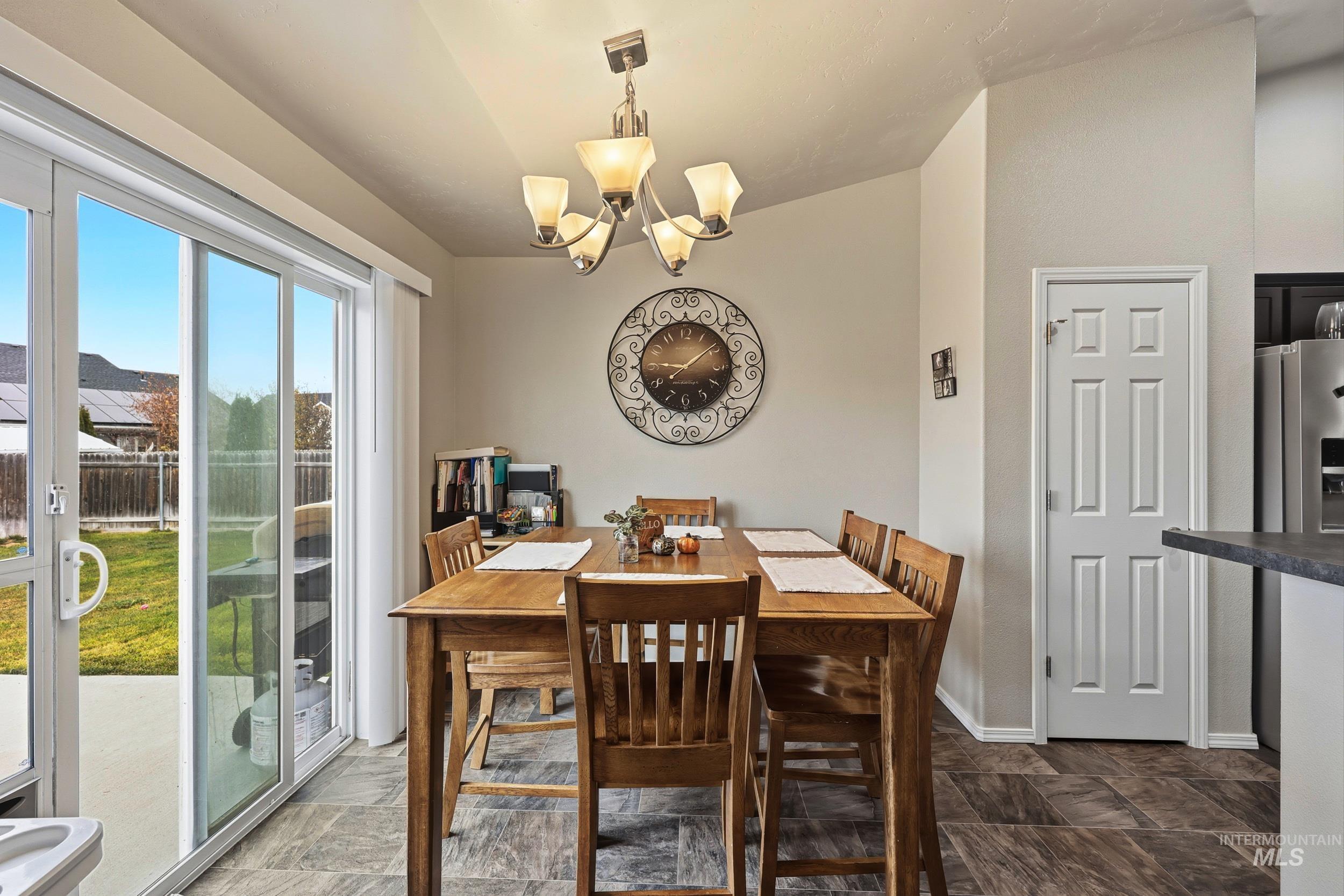 Dining room featuring a chandelier and stone finish flooring