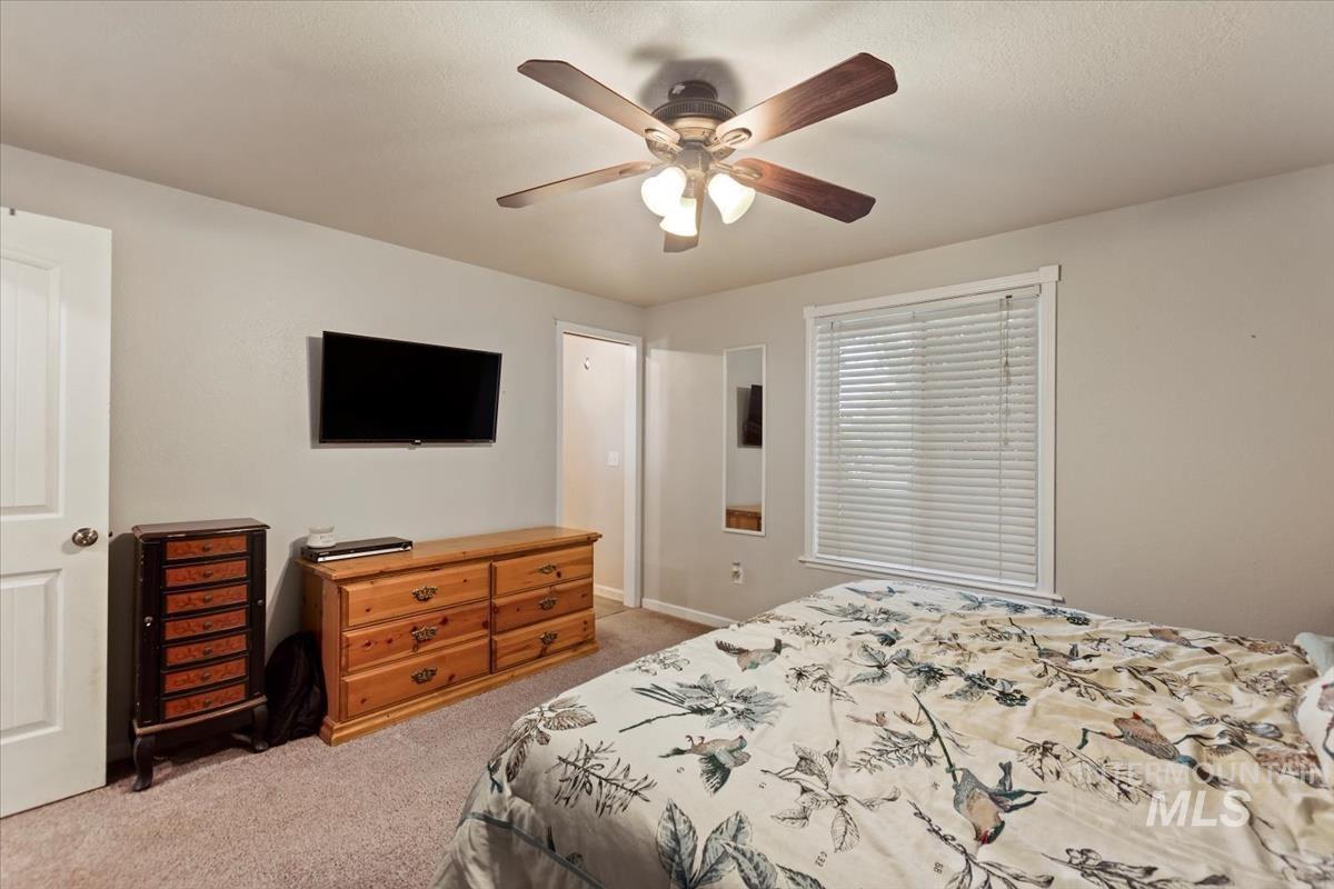 Bedroom featuring light colored carpet and ceiling fan