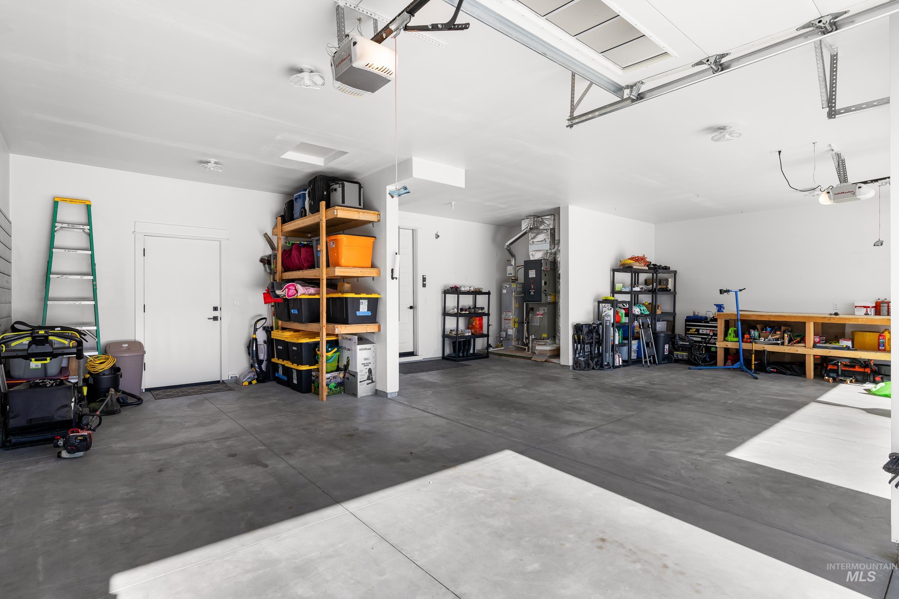 Garage featuring a garage door opener and gas water heater
