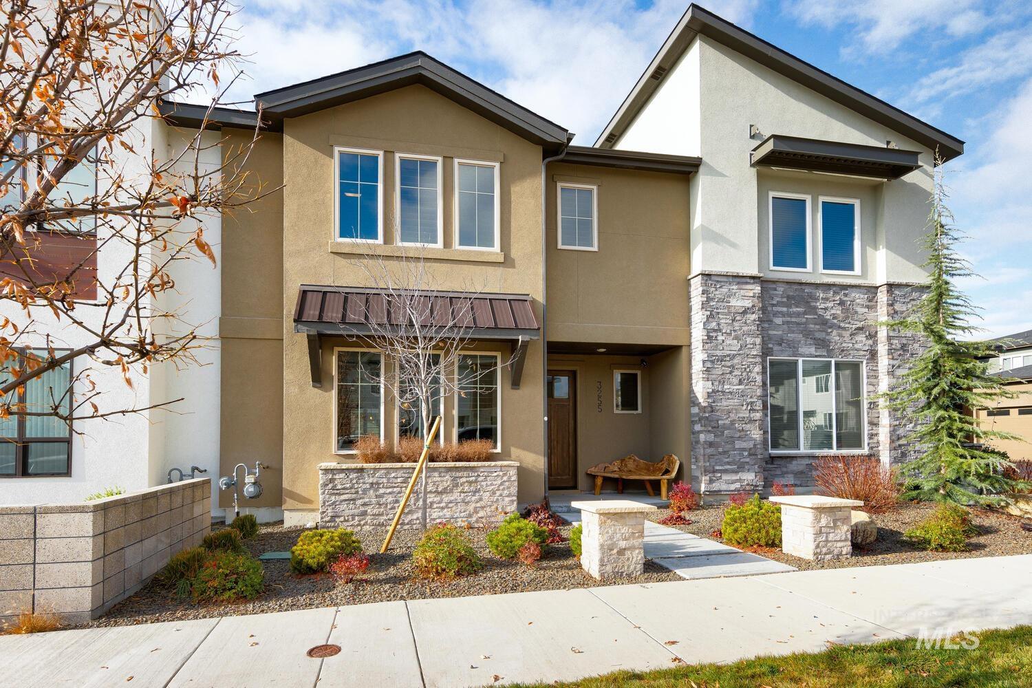 View of front of house featuring stucco siding, stone siding, and covered porch