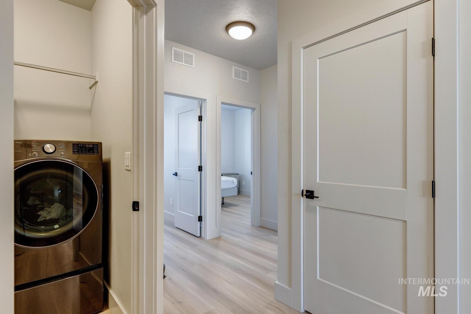 Laundry area featuring washer / dryer and light wood-style flooring