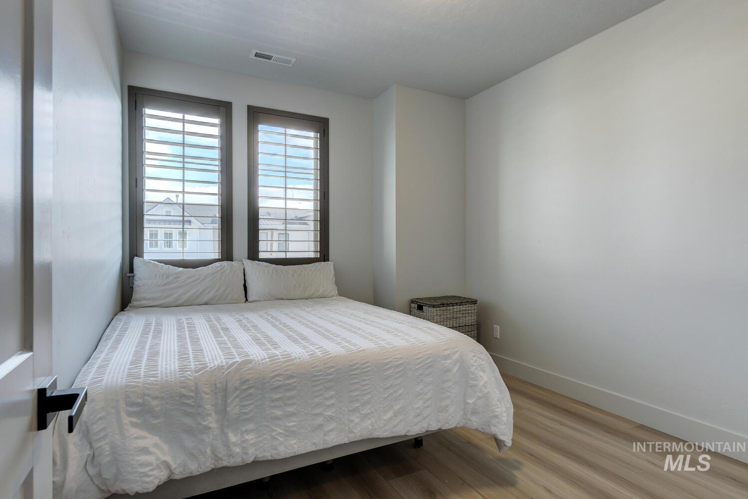 Bedroom with wood finished floors and baseboards