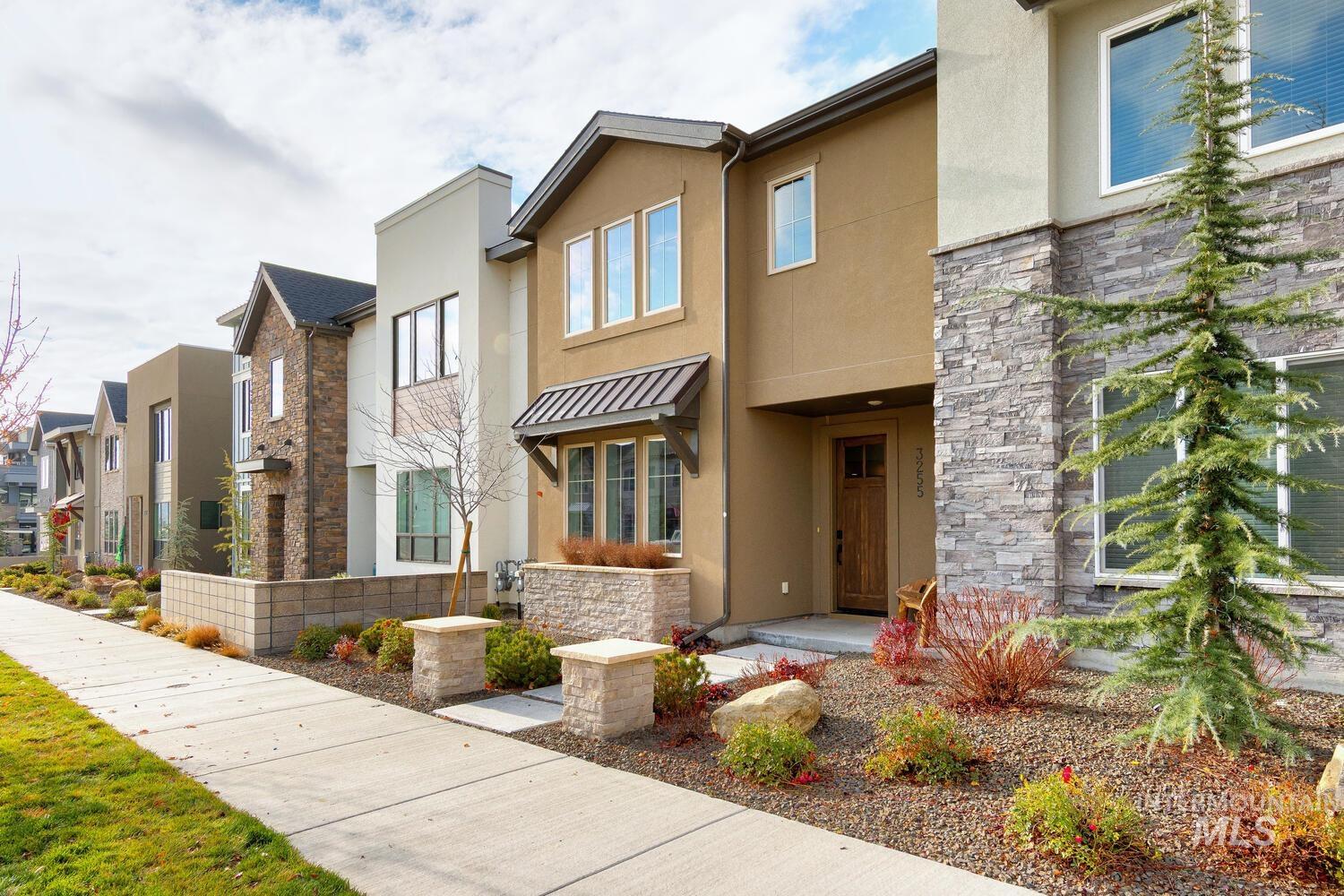 Contemporary house featuring stucco siding, stone siding, and a residential view