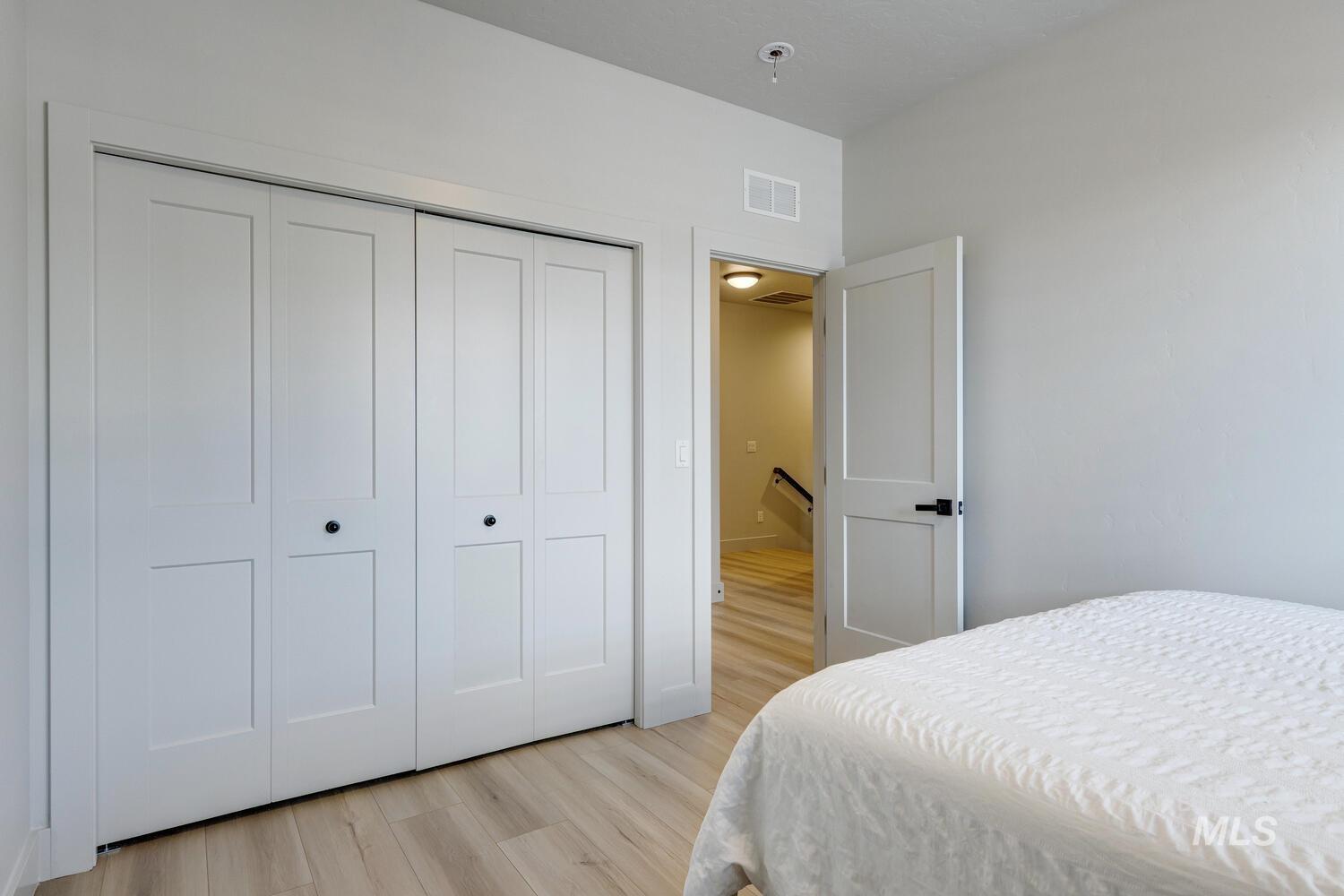 Bedroom with light wood finished floors and a closet