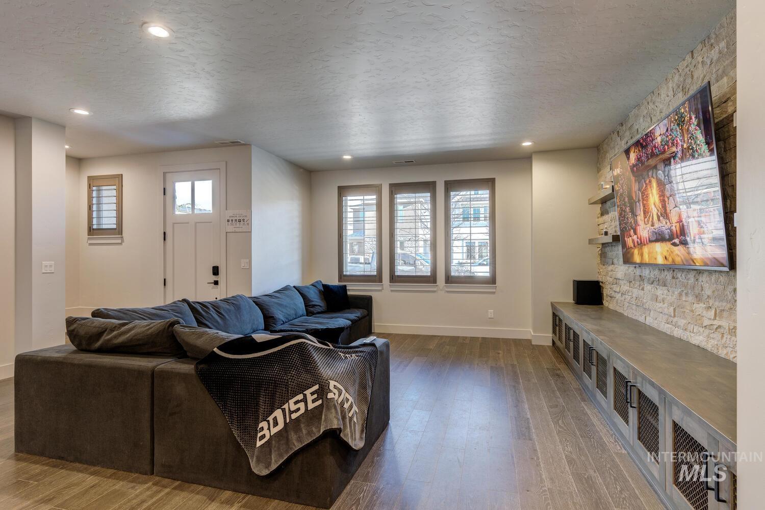 Living area featuring a textured ceiling, hardwood / wood-style flooring, and recessed lighting