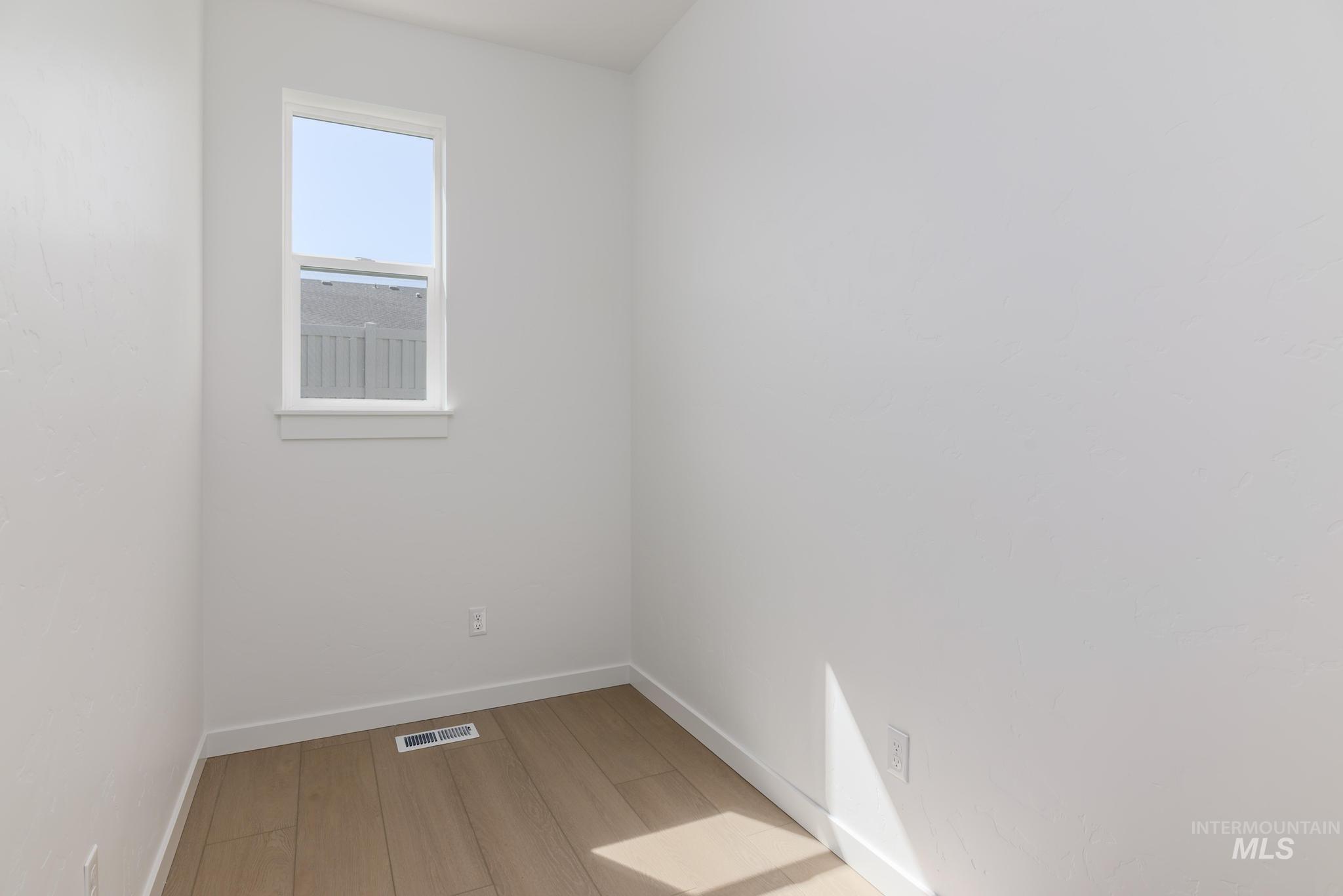 Unfurnished room featuring baseboards and light wood finished floors