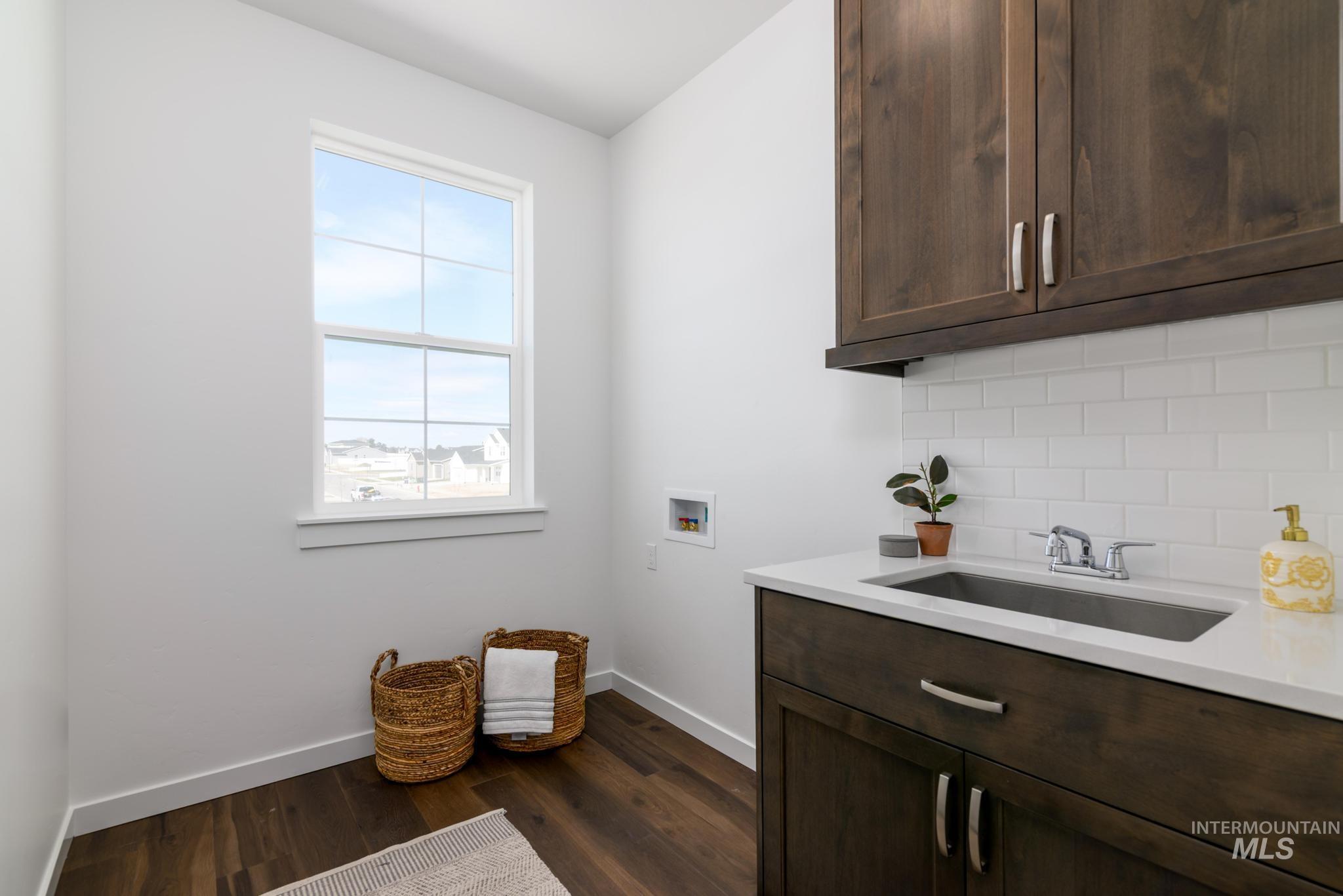 Laundry area featuring cabinet space, hookup for a washing machine, and dark wood-type flooring