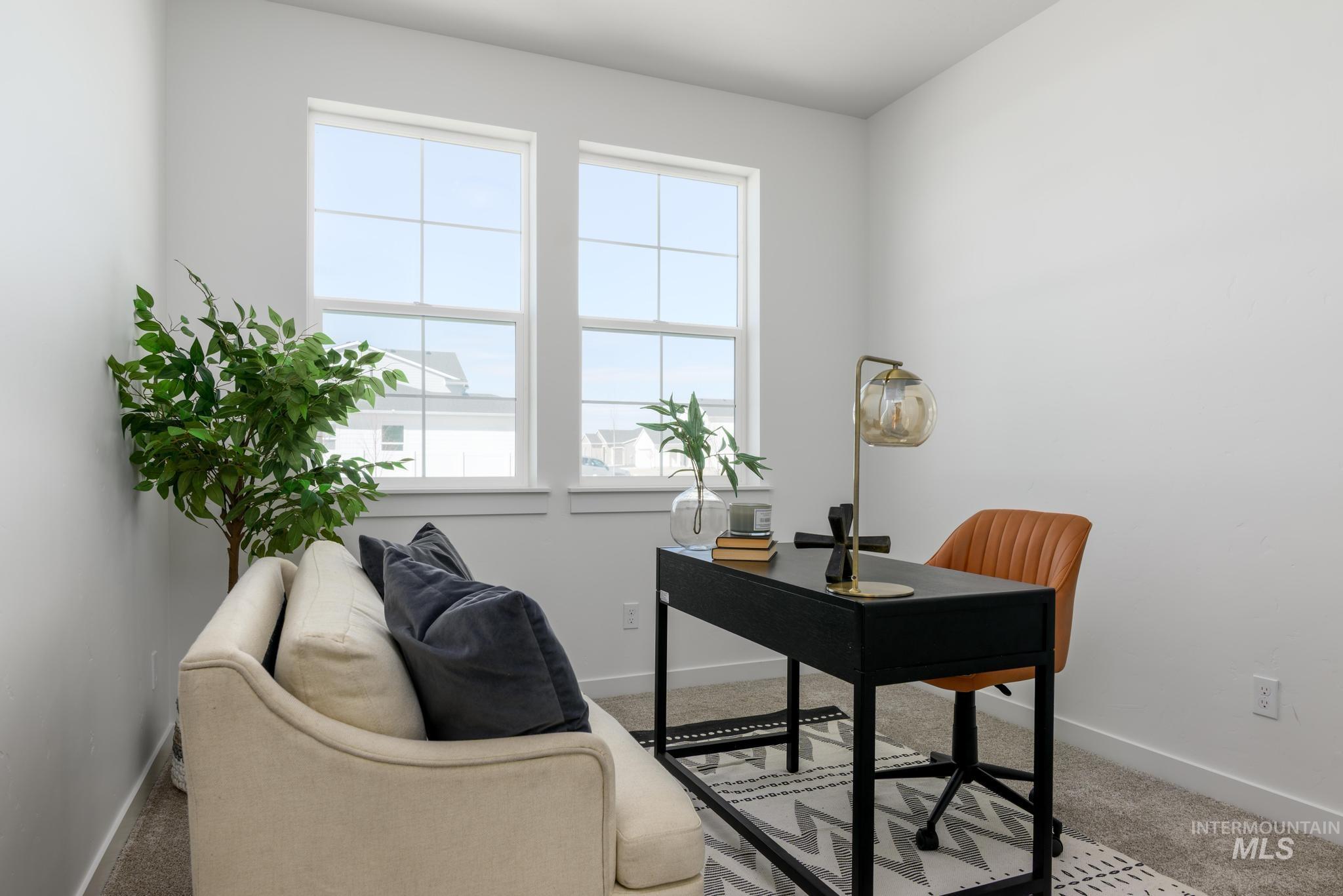 Carpeted home office featuring baseboards