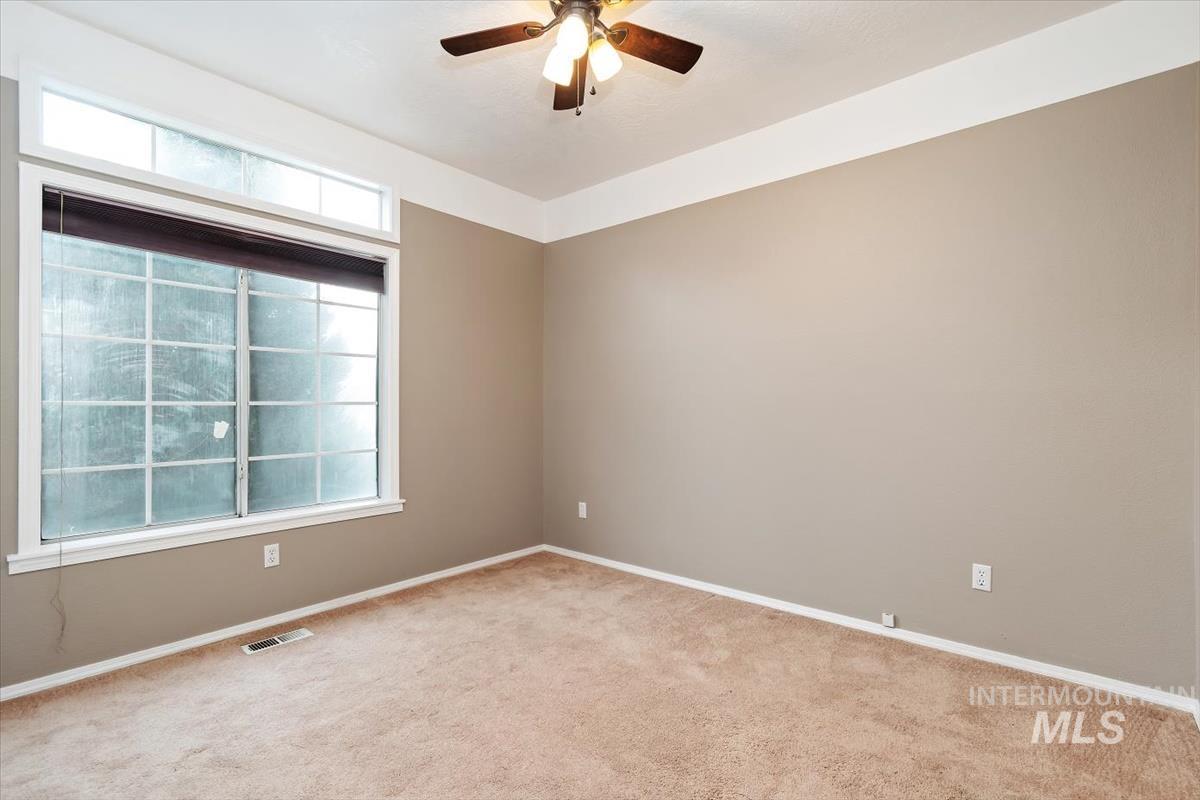 Spare room featuring carpet floors and a ceiling fan