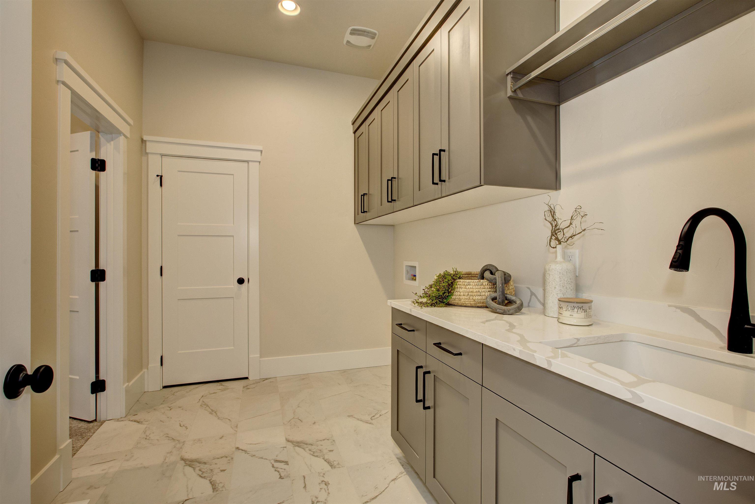 Laundry room with recessed lighting, cabinet space, hookup for a washing machine, and light marble finish floors