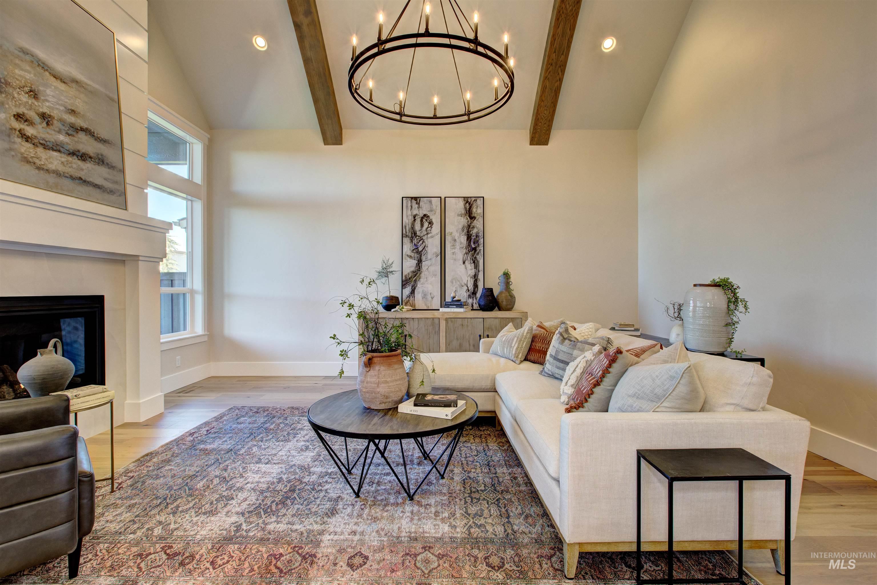 Living room featuring light wood-style floors, a glass covered fireplace, recessed lighting, and a chandelier