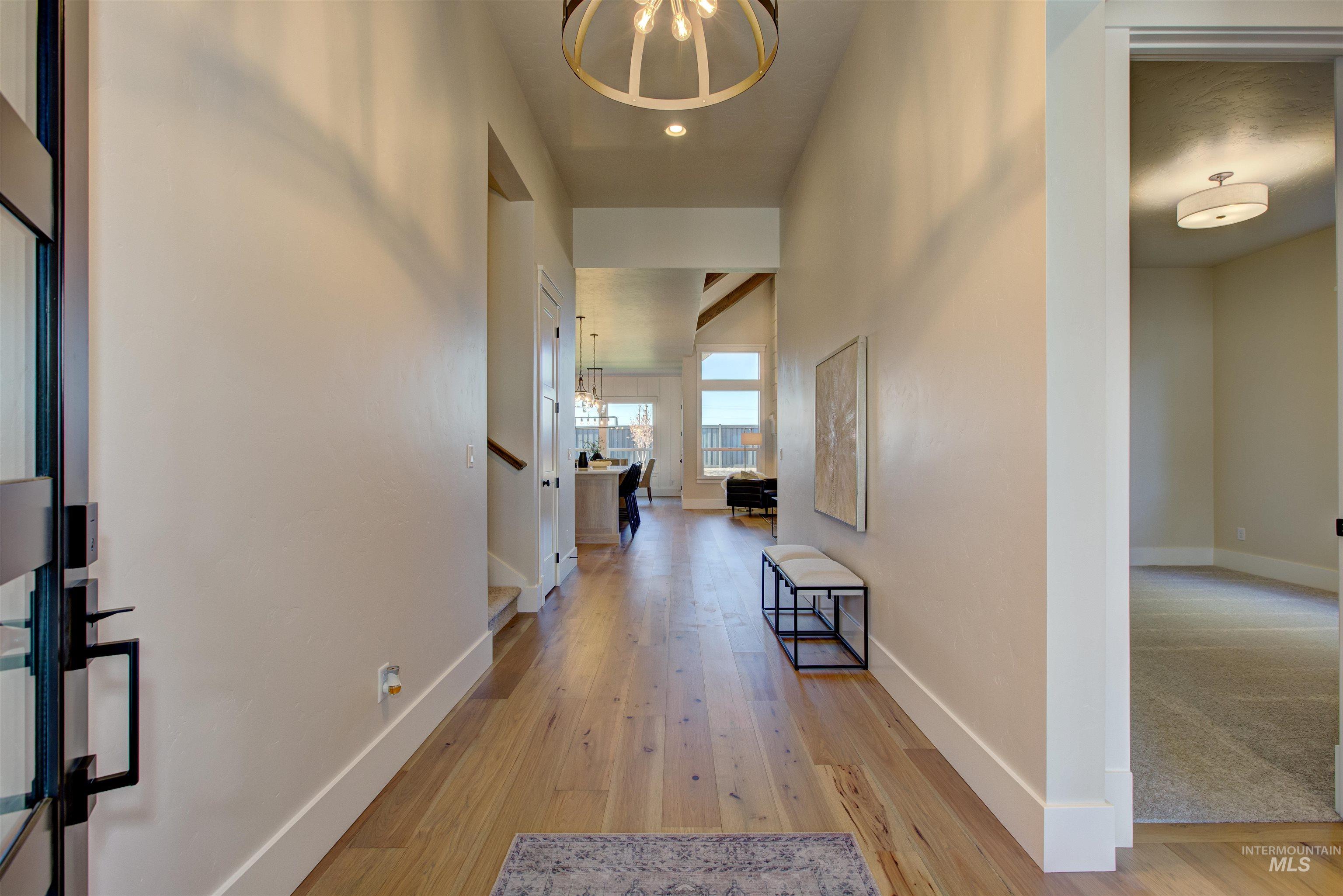 Hallway with a chandelier, light wood-type flooring, and recessed lighting