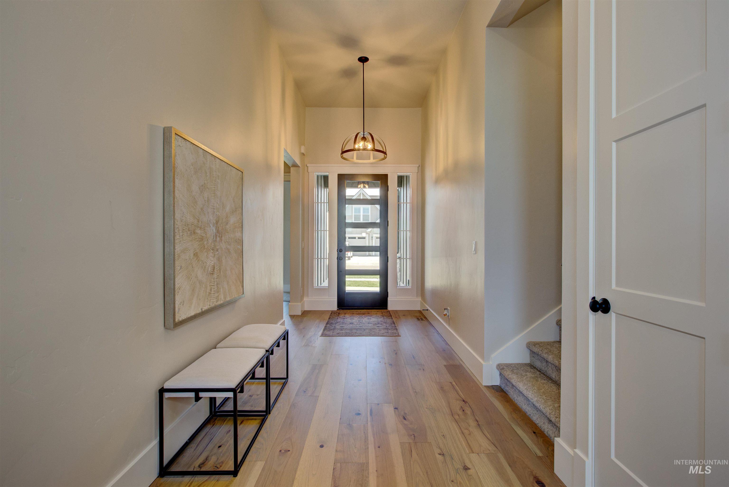 Foyer entrance featuring light wood-style flooring, stairway, and a chandelier