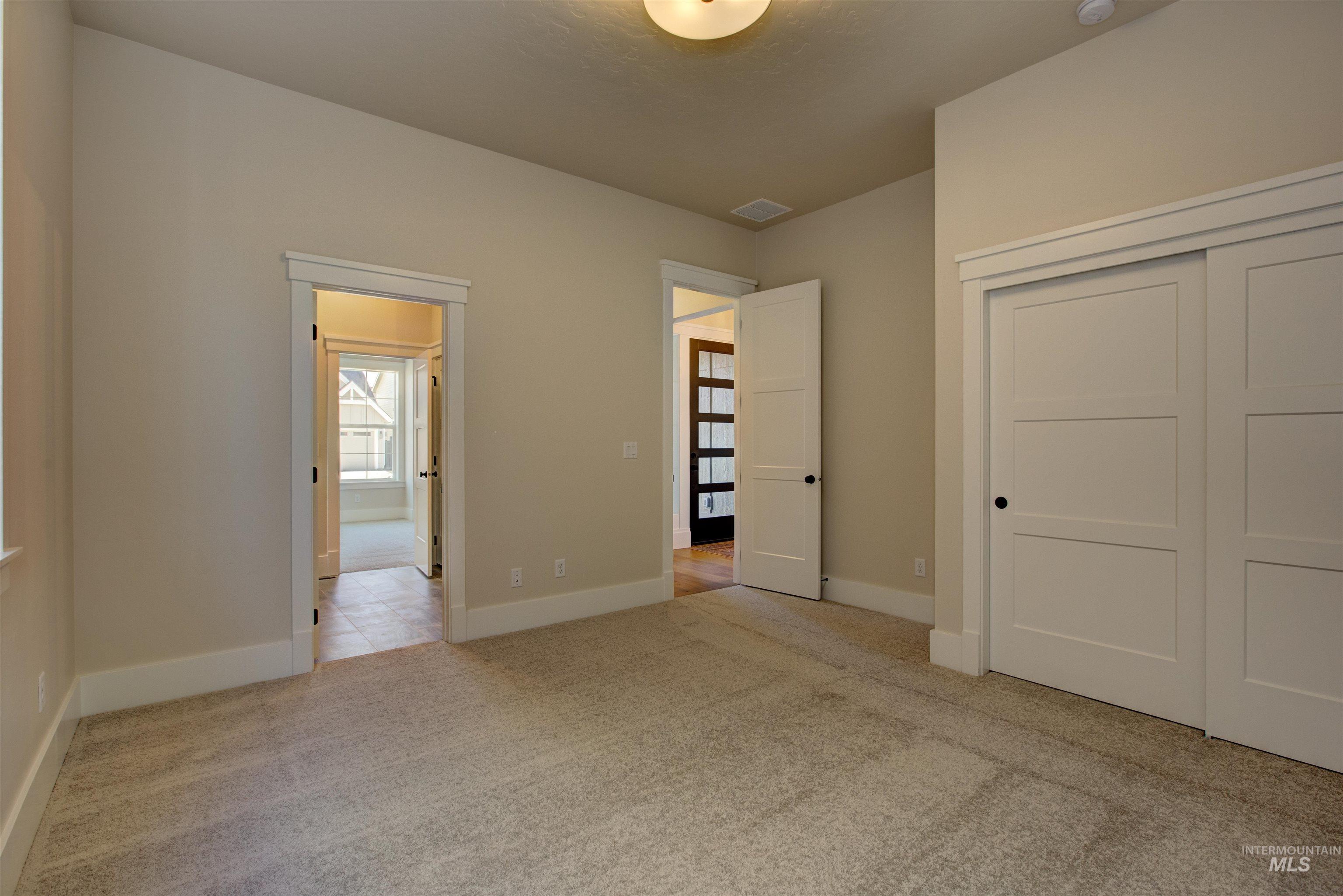 Unfurnished bedroom with light carpet and a closet