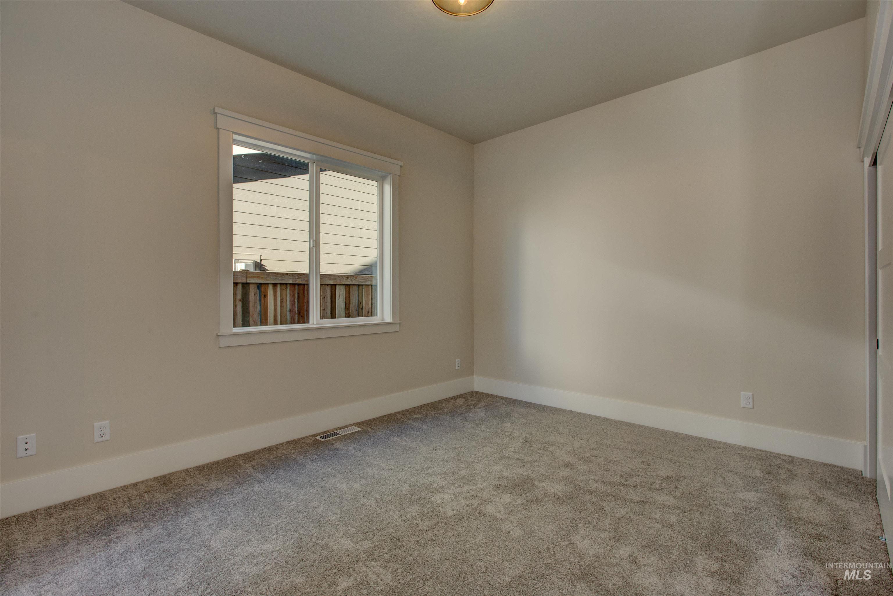 Carpeted spare room with baseboards