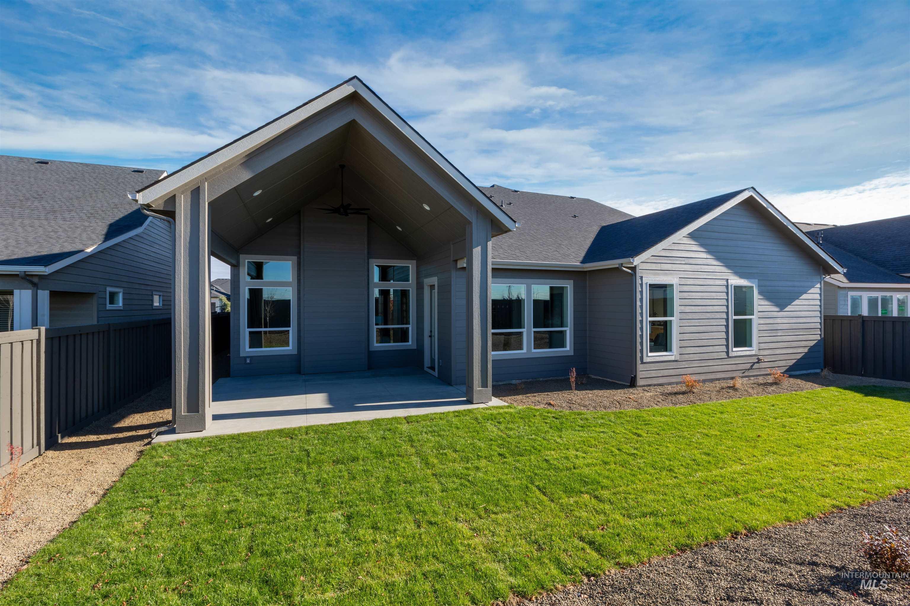 Rear view of house with a fenced backyard and a patio area