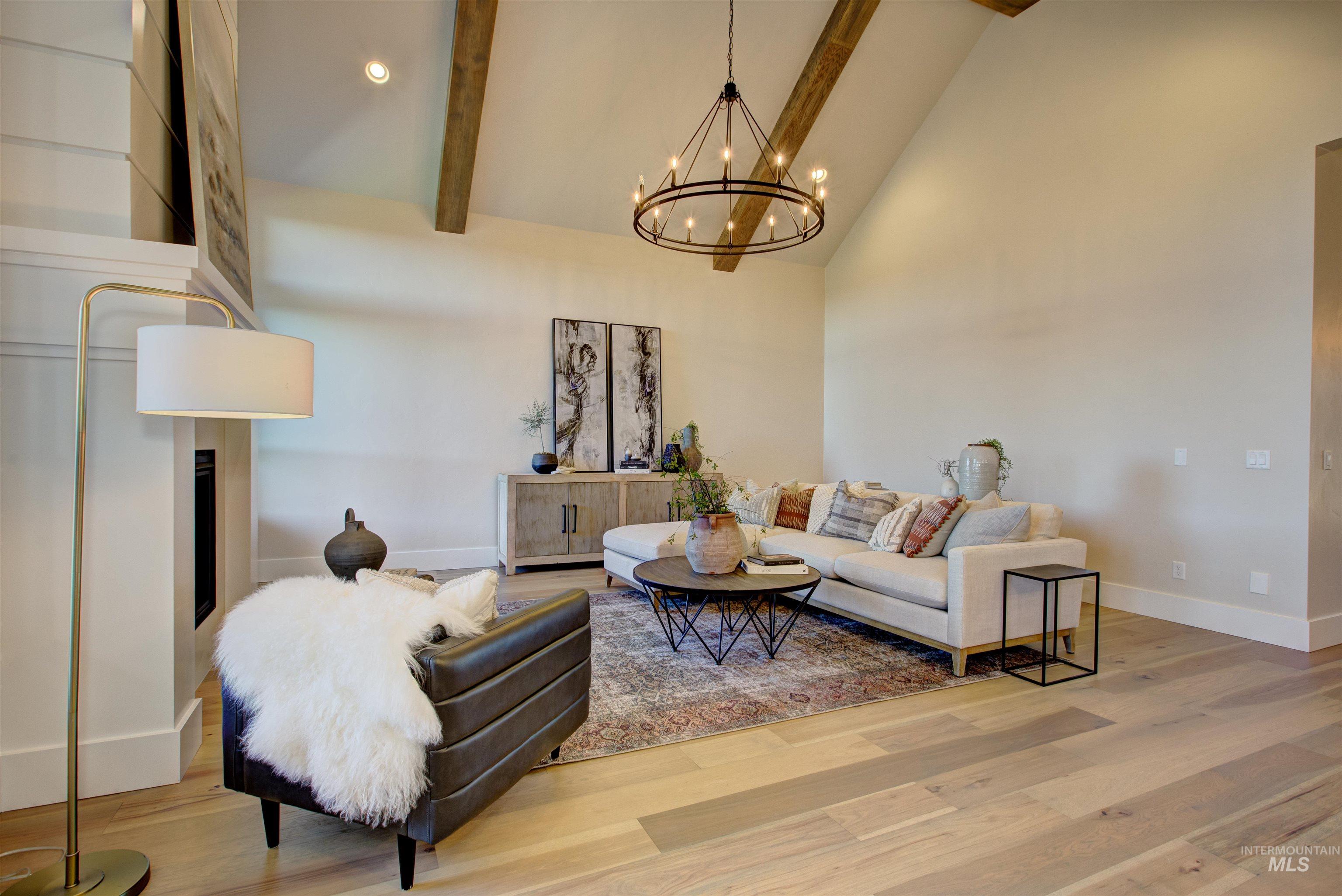 Living room featuring high vaulted ceiling, beam ceiling, wood finished floors, recessed lighting, and a chandelier