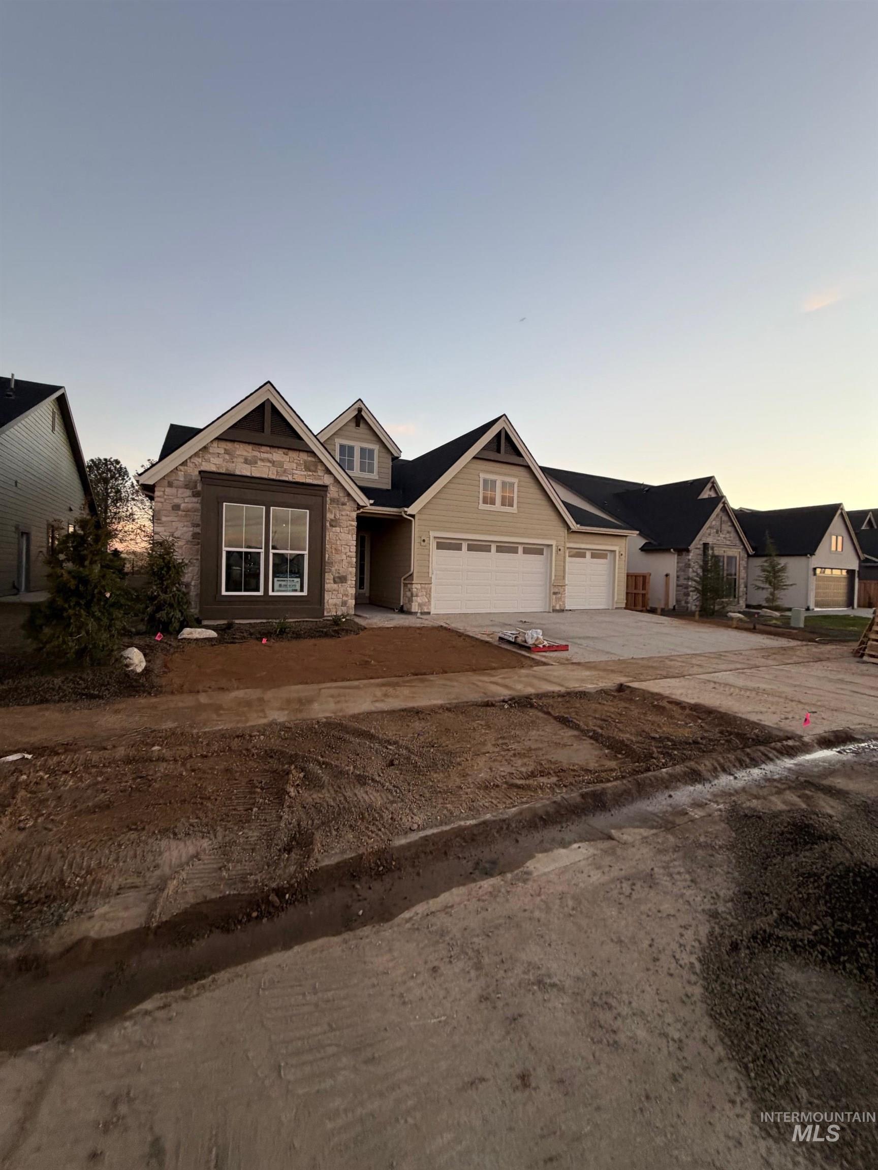 Craftsman-style house featuring stone siding and concrete driveway