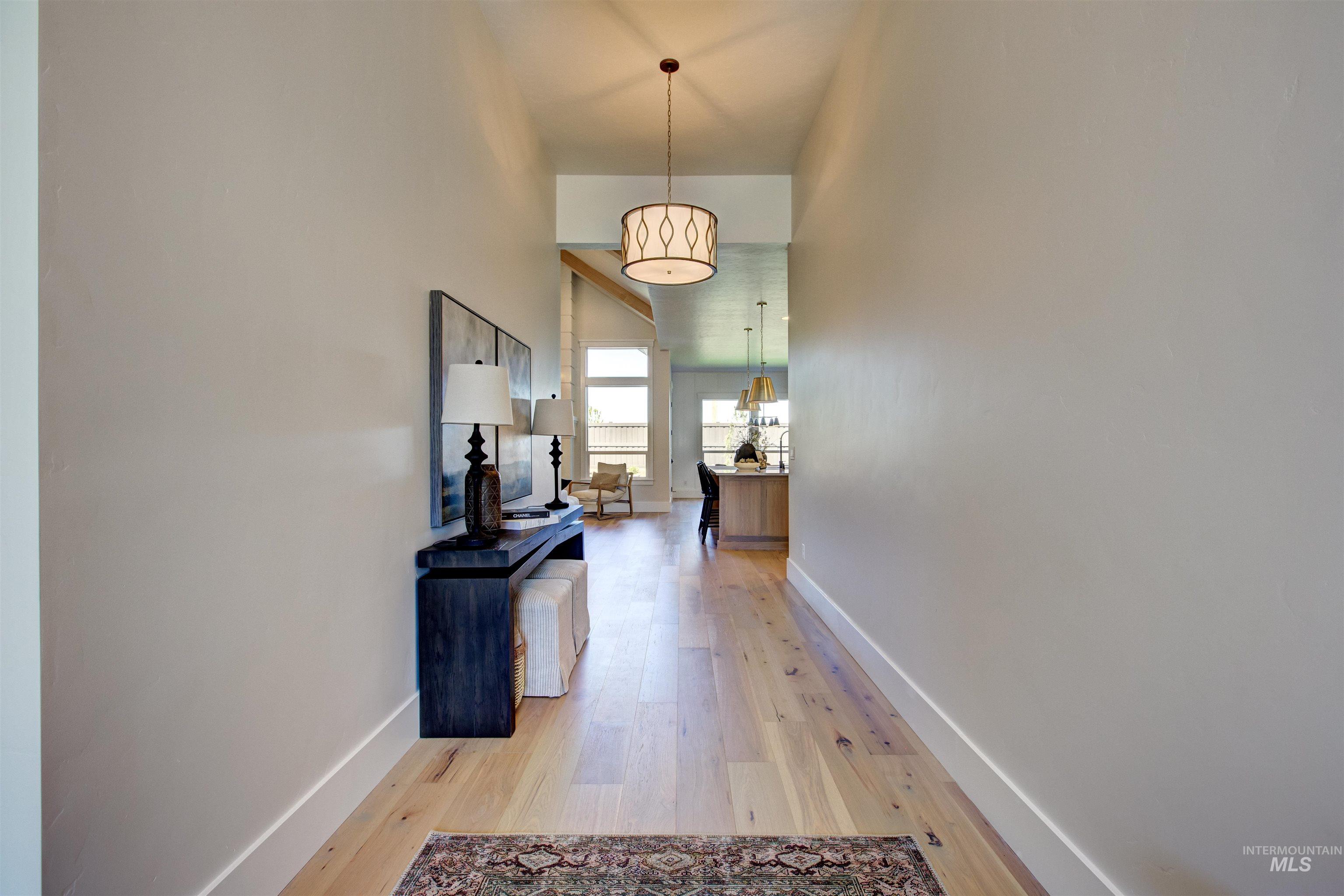 Corridor with light wood finished floors and a towering ceiling