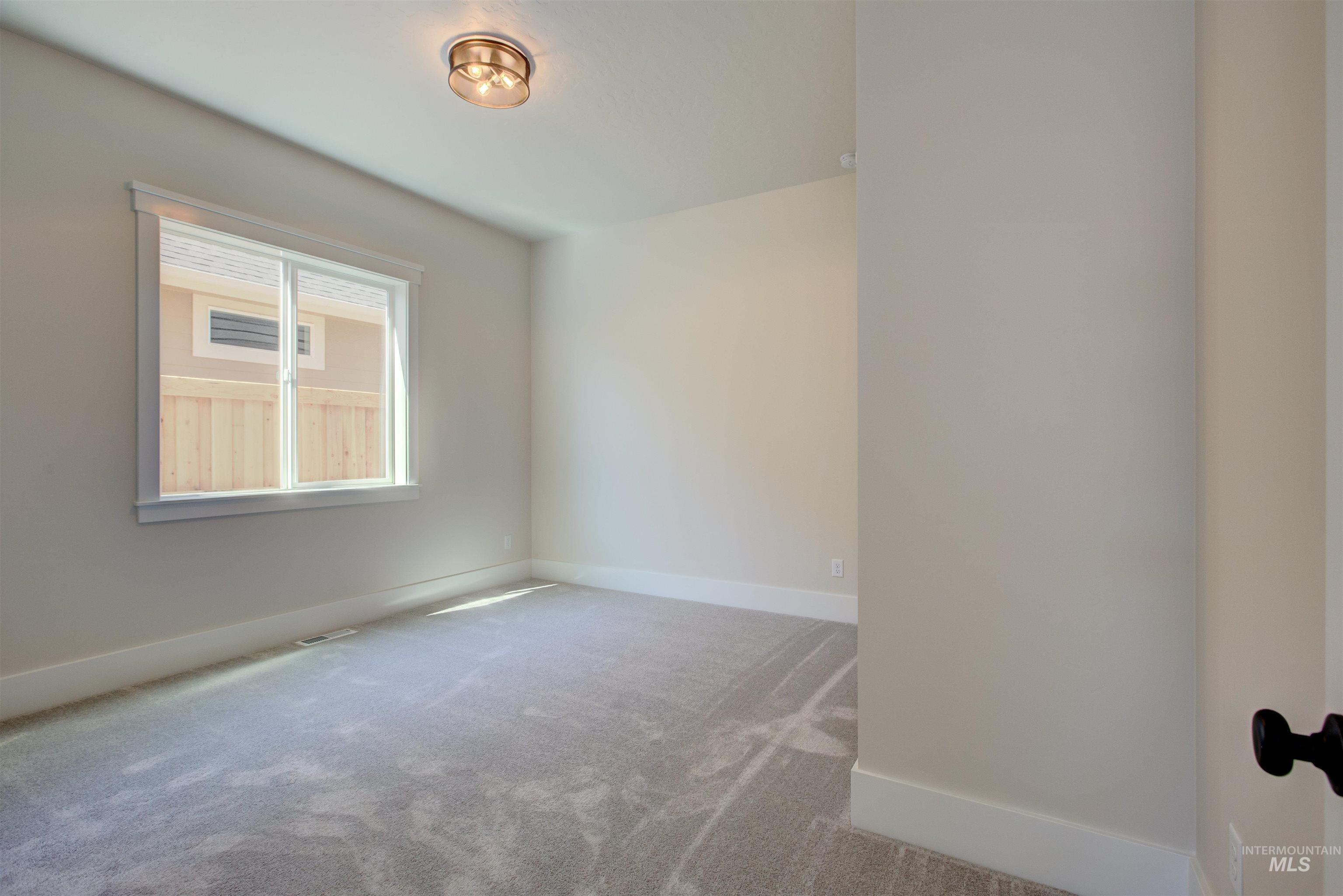 Carpeted empty room featuring baseboards