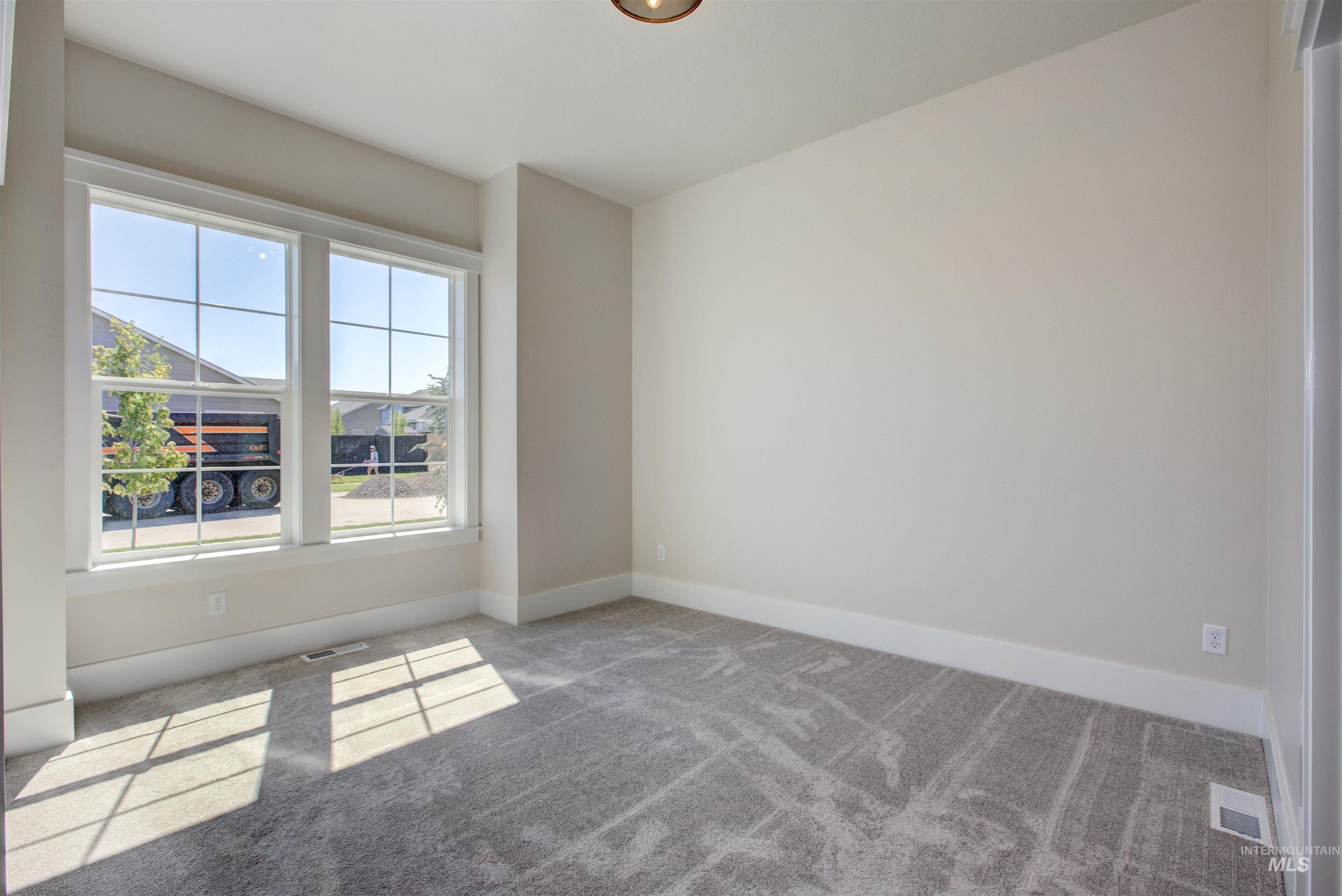 Carpeted empty room with baseboards